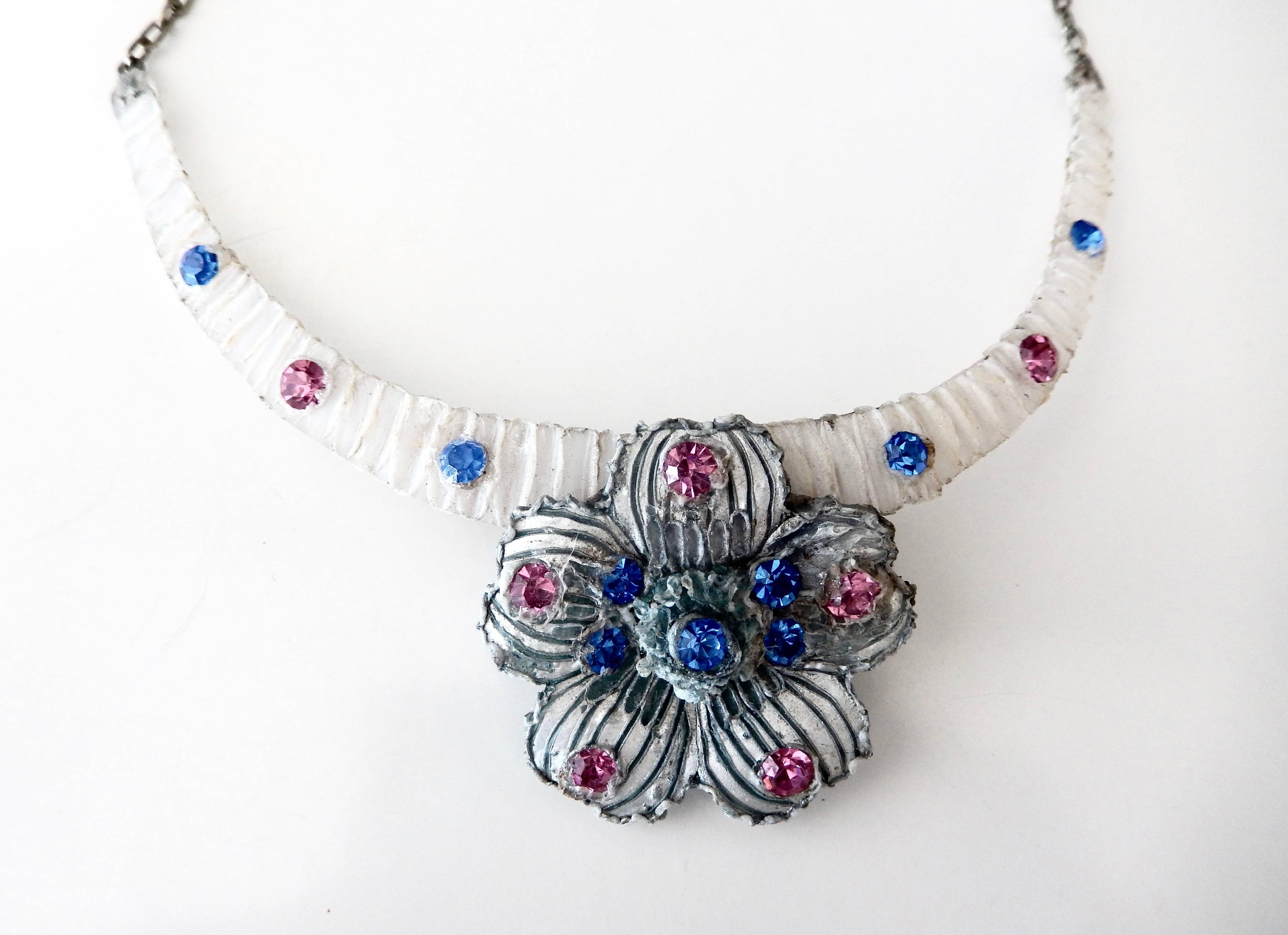 Handcrafted, sculptural necklace by French designer Henry Perichon, known for his innovative jewelry. The central floral pendant is constructed of silvered resin with pink and blue stones giving the necklace a dreamlike, magical appearance. A fine