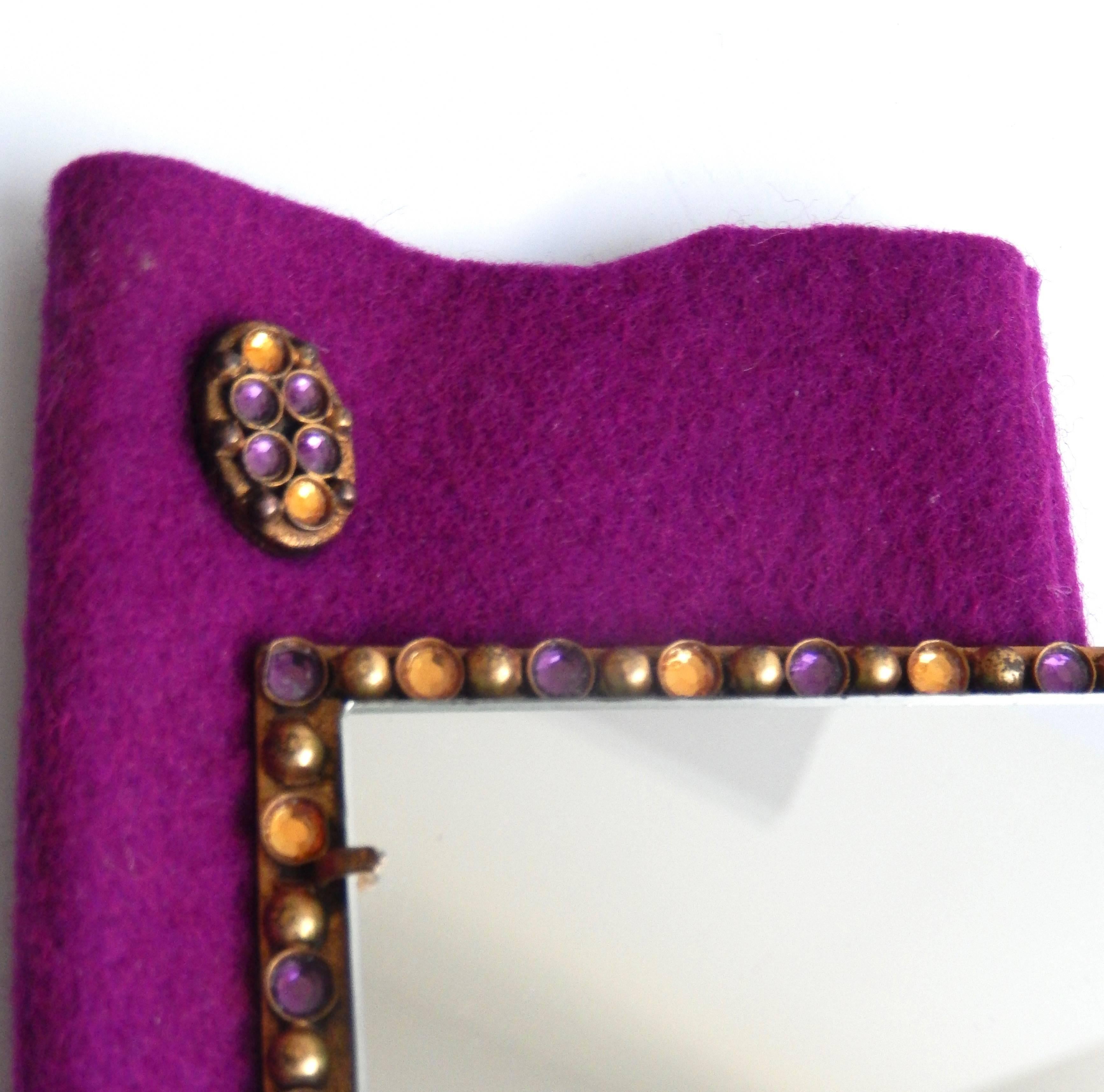 A scarce, bejeweled handbag mirror with it's original decorated felt pouch by the French designer Henry Perichon (1910-72).  The design is inspired by Renaissance and Medieval jewelry with its elegant border of colored glass stones resembling