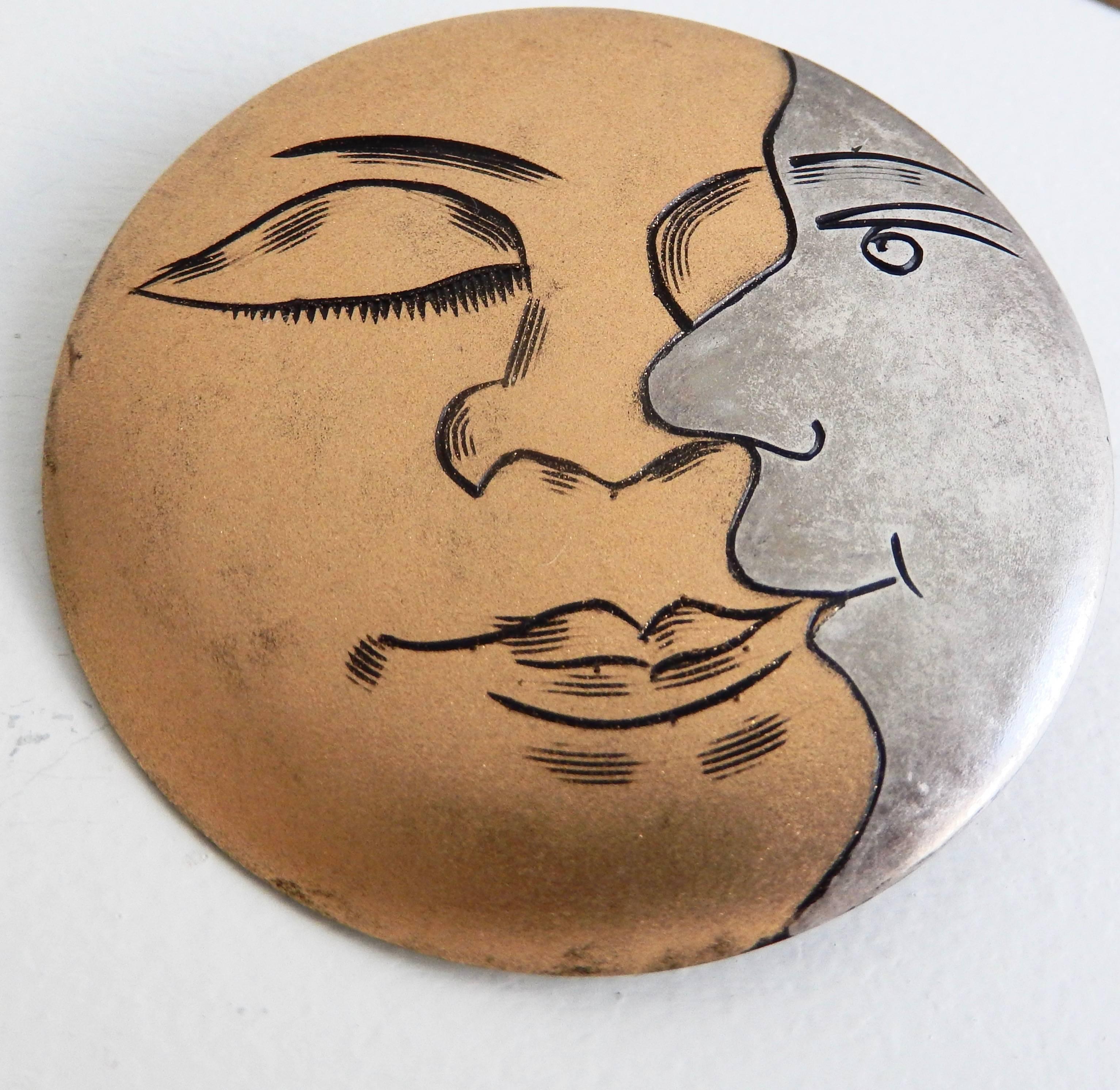 
Art Deco brooches of silver and gold gilt with a clever design of two faces--one in profile.  A sun and a son? Two sides of the man in the moon?  The witty graphic design is reminiscent of Fornasetti's stylized moon images.

Price is per item