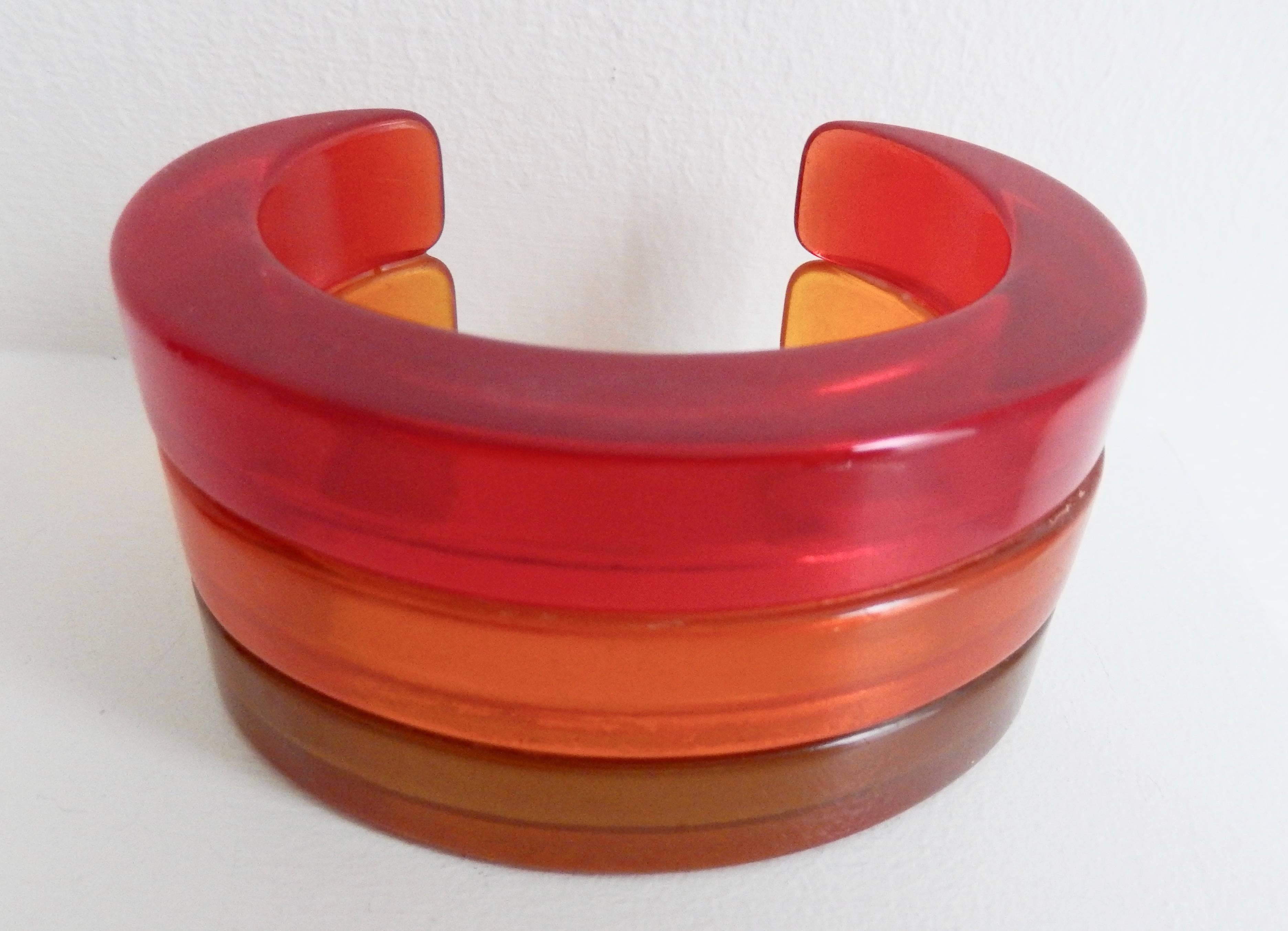 An unusual tri-color cuff that combines three vintage bakelite bracelets, joined at a later date, to create a wide band.   Muted shades of red, orange and lime green transparent bakelite form a beautiful design.  Perfect fit for a small wrist (size