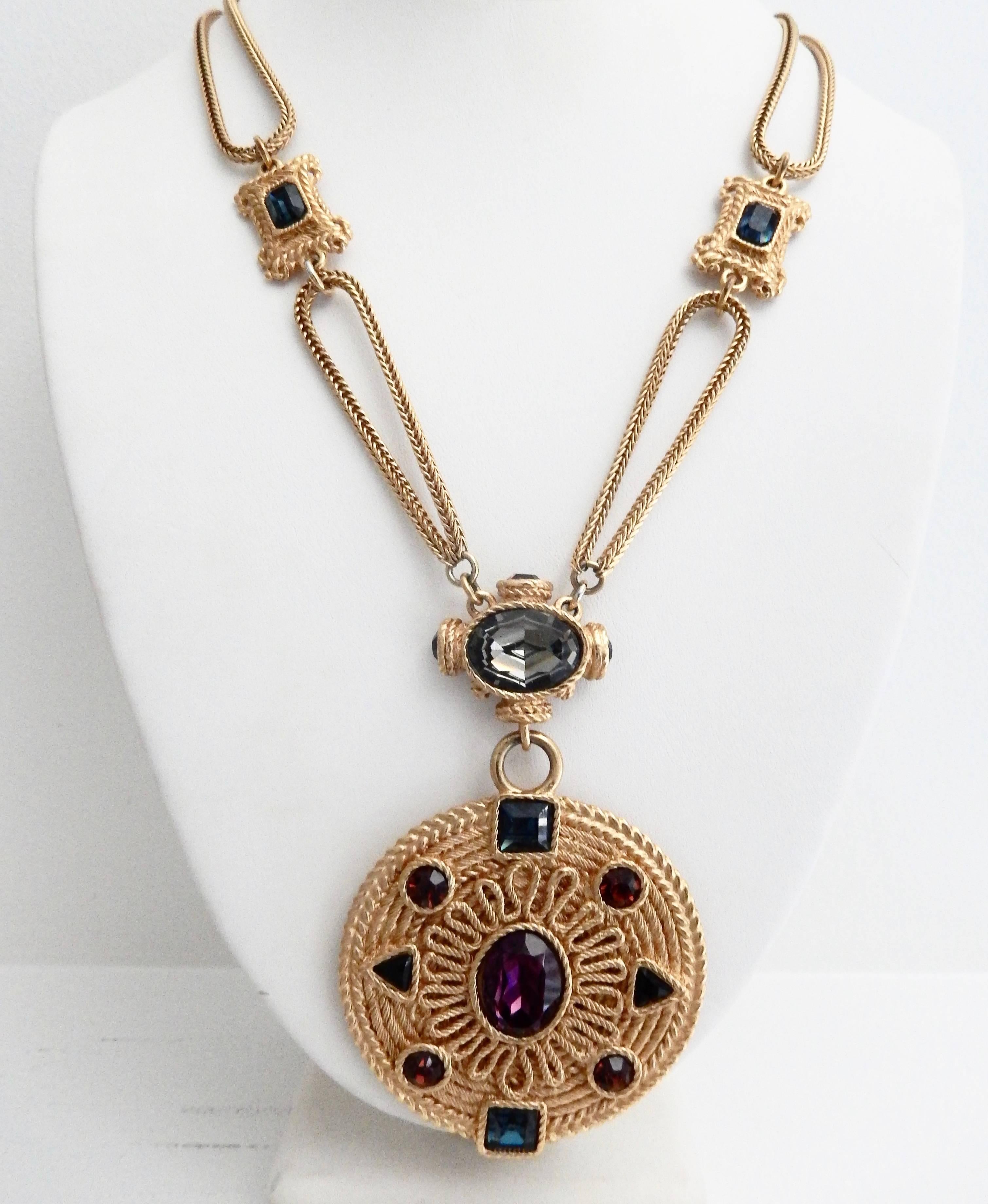 A exquisite, gilt metal pendant necklace with a center amethyst, surrounded by blue and grey faux gemstones, by Spanish couturier Cristobal Balenciaga (1895-1972).  The opulent design reflects Balenciaga's interest in the Spanish Renaissance. In