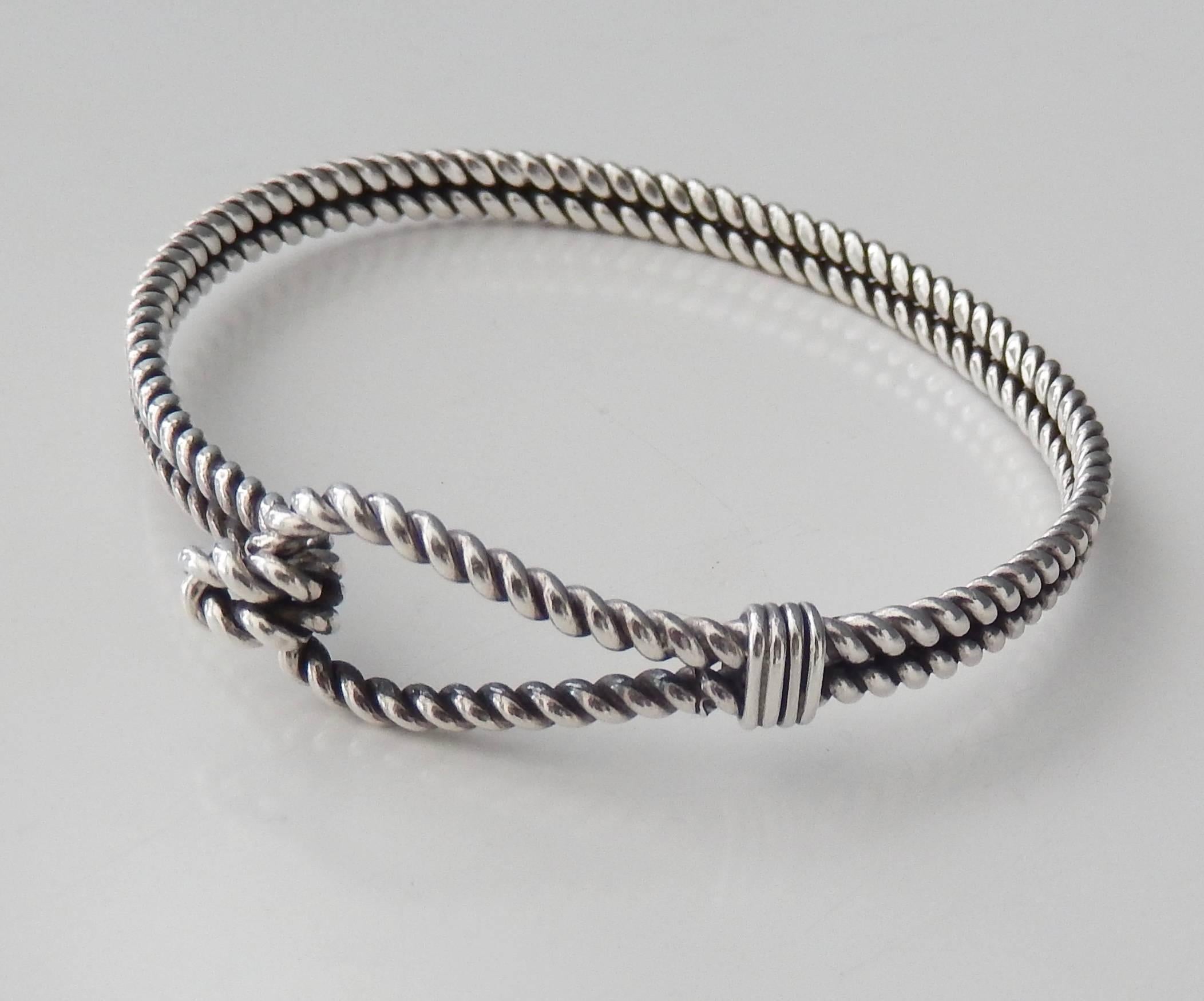 A modernist, sophisticated sterling silver bracelet with an integrated closure by Gucci.  A very comfortable fit for a small wrist. 
Marked:  GUCCI ITALY 925

Approximate wrist size:  7 in