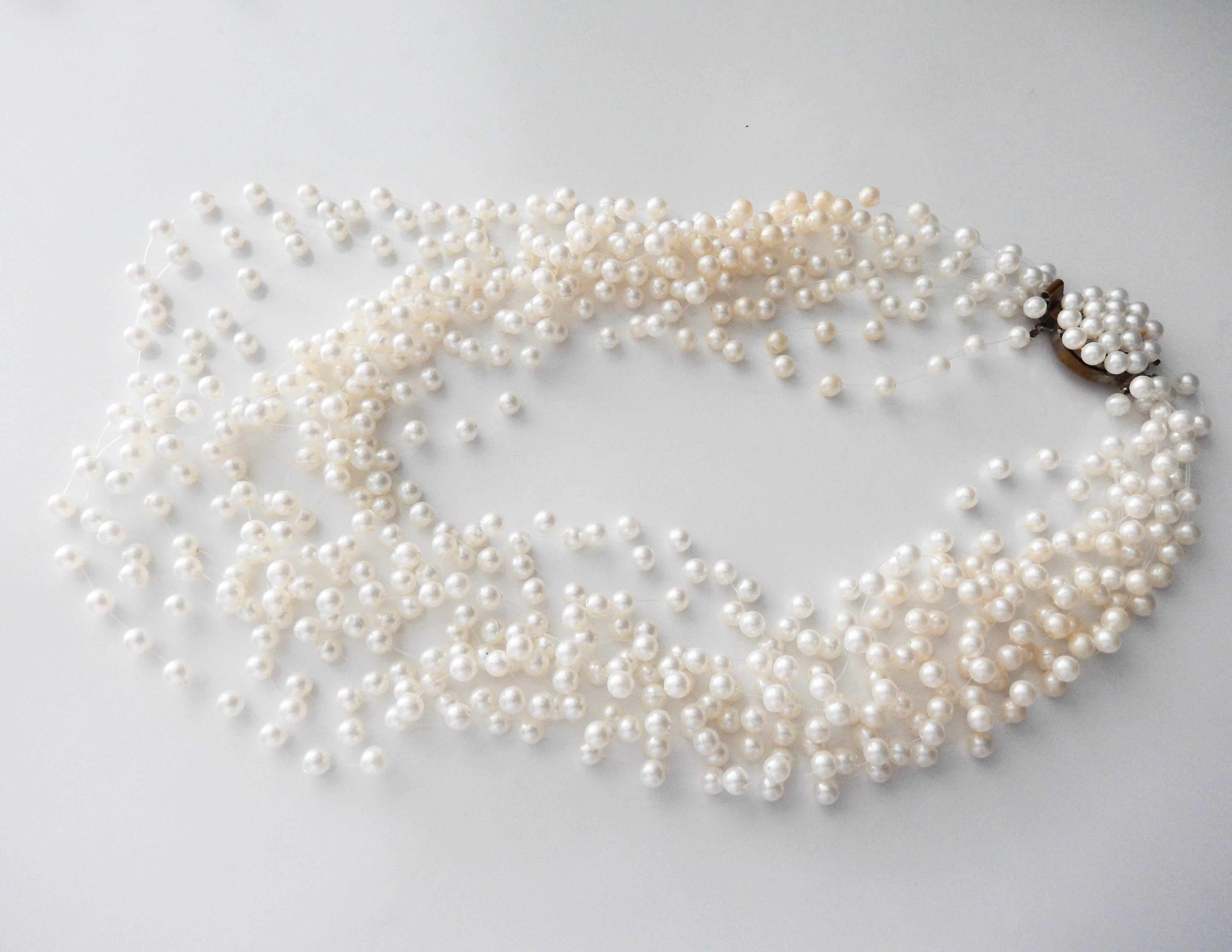 A sophisticated and graceful pearl necklace by Langani with her signature black bead. In 1957 Anna Lang copyrighted her technique of stringing faux pearls on lightweight plastic cord giving the illusion that the necklace is 
