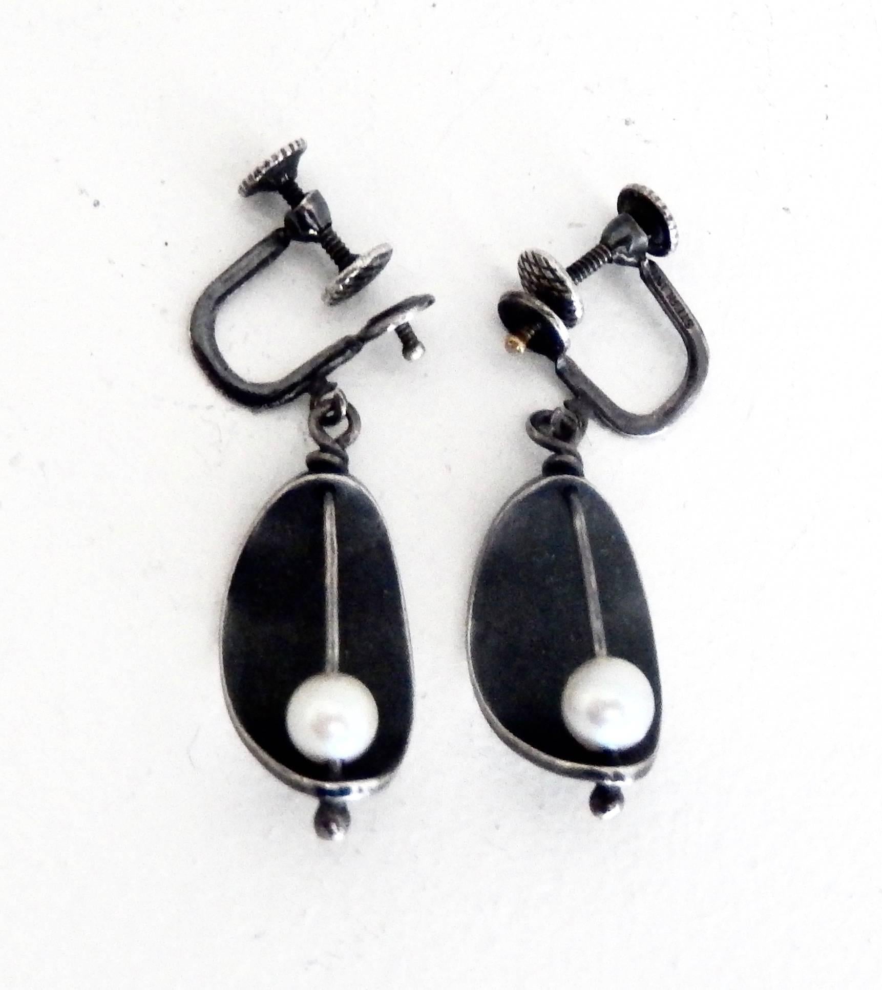 A pair of mid-century modern earrings by the highly-regarded New York modernist jeweler Ed Wiener (1918-1991).  As was typical of Wiener's work, these earrings demonstrate his mastery of silversmithing and sculptural focus.  Earrings are screw back.