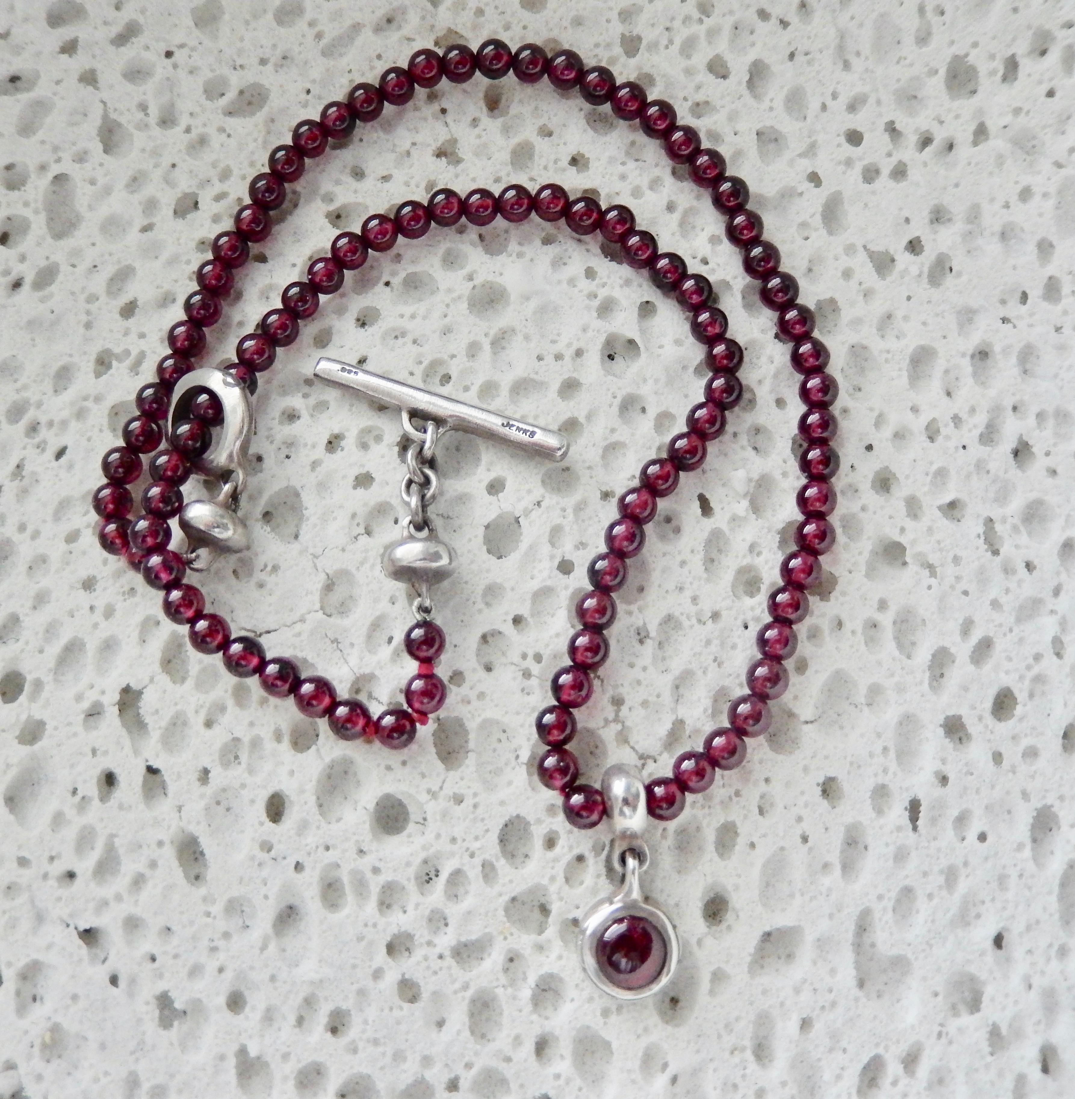 An amethyst beaded necklace with sterling pendant and clasp by the American jewelry designer Lisa Jenks, known for her fine workmanship and innovative designs. Her handmade pieces focus on simple modernist forms inspired by diverse cultures,
