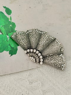 CHRISTIAN DIOR John Galliano : broche imposante ornée de cristaux argentés texturés en forme d'éventail, modèle emblématique
