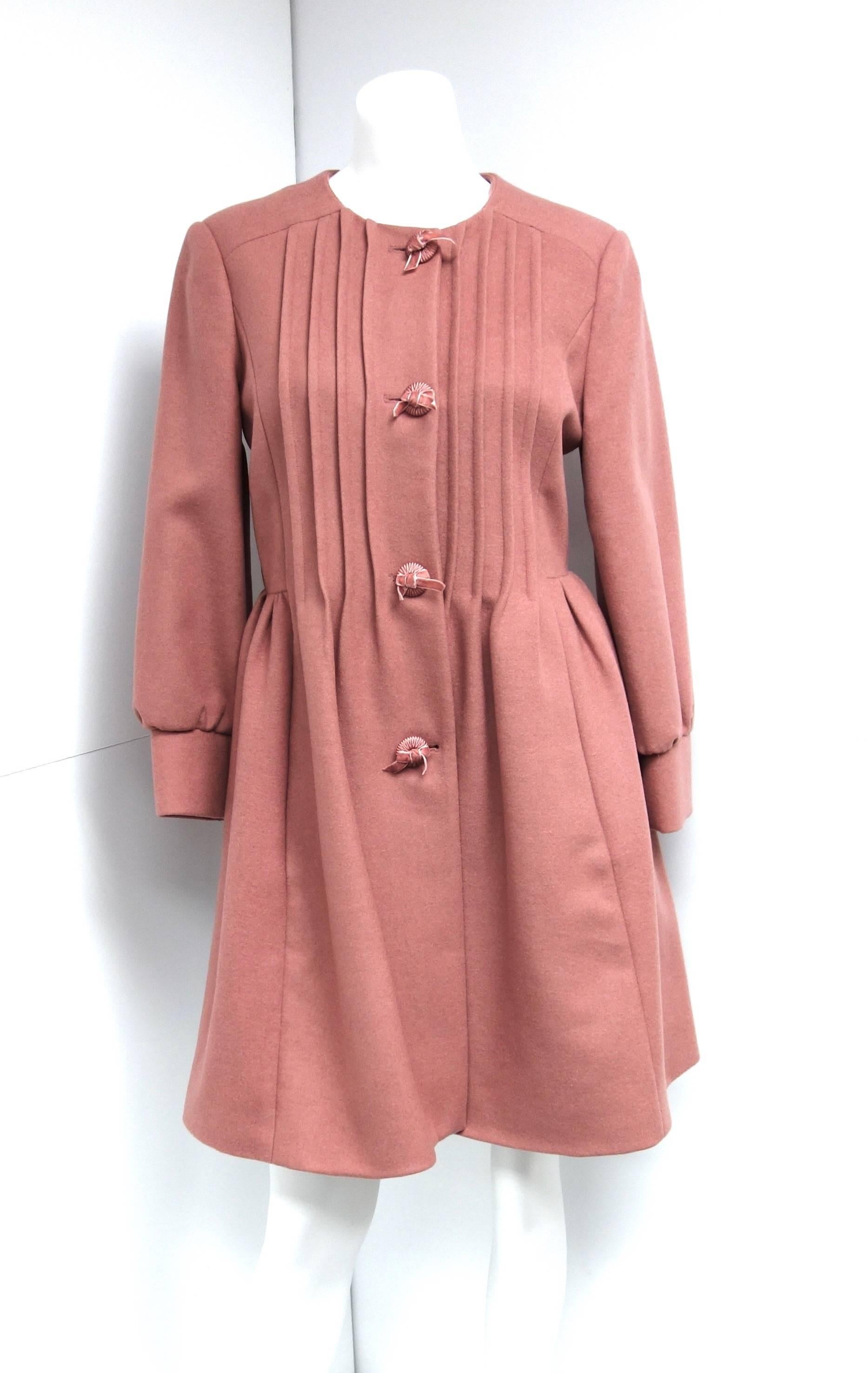 Salmon pink wool single breasted coat from Red Valentino.
Valentino’s more youthful line, a fresh take on the Italian label’s elegance, Red Valentino is short for Romantic Eccentric Dress. The house’s signature ladylike pieces still play a key