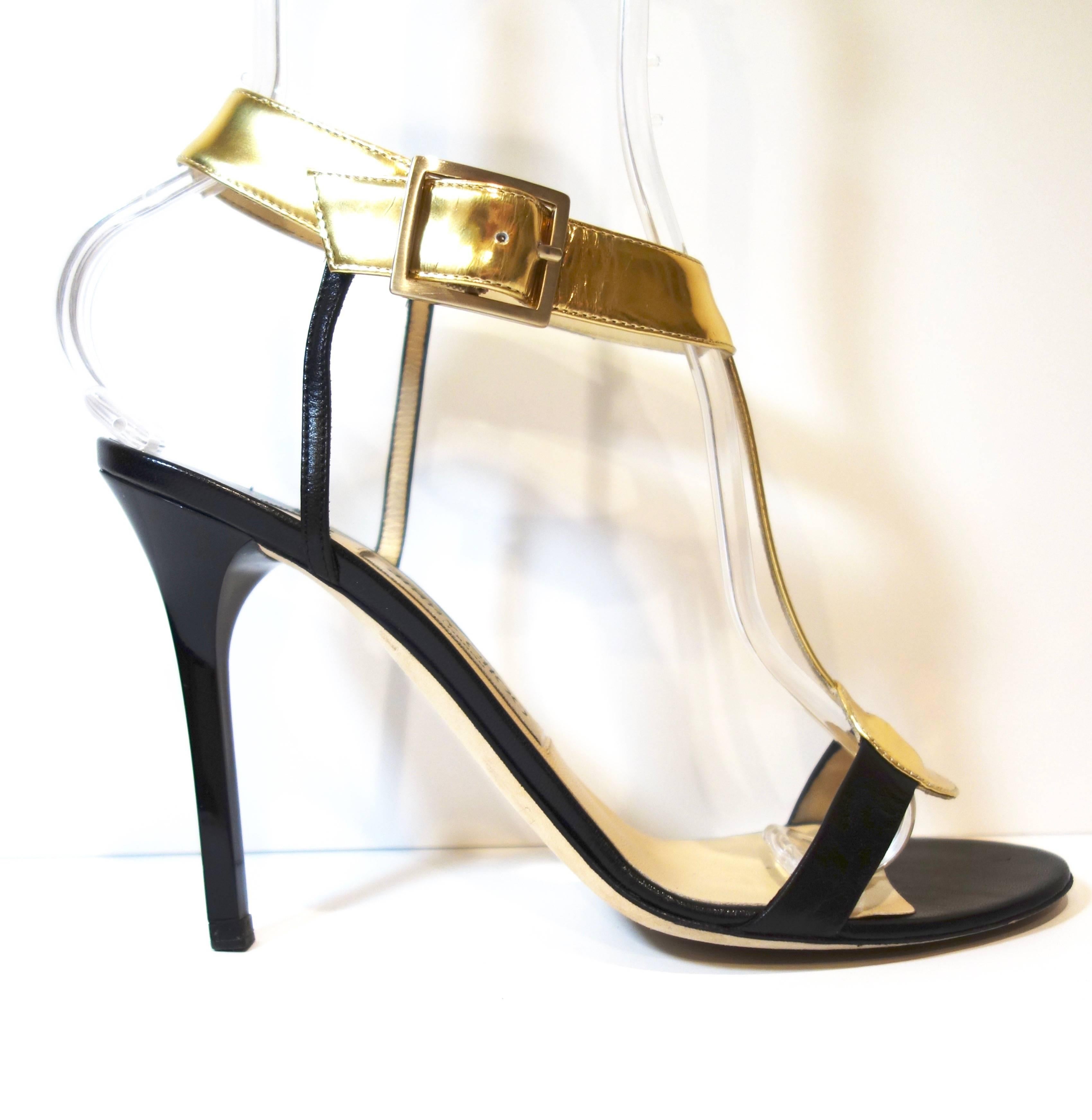 Jimmy Choo Black Leather Mirrored T-Strap Latch Sandals
Size: 38.5
Retail was: $595 
Color: Black / Gold
Smooth leather upper with mirrored leather detail. Rounded open toe.
Mirrored leather t-strap. Adjustable ankle strap with goldtone
