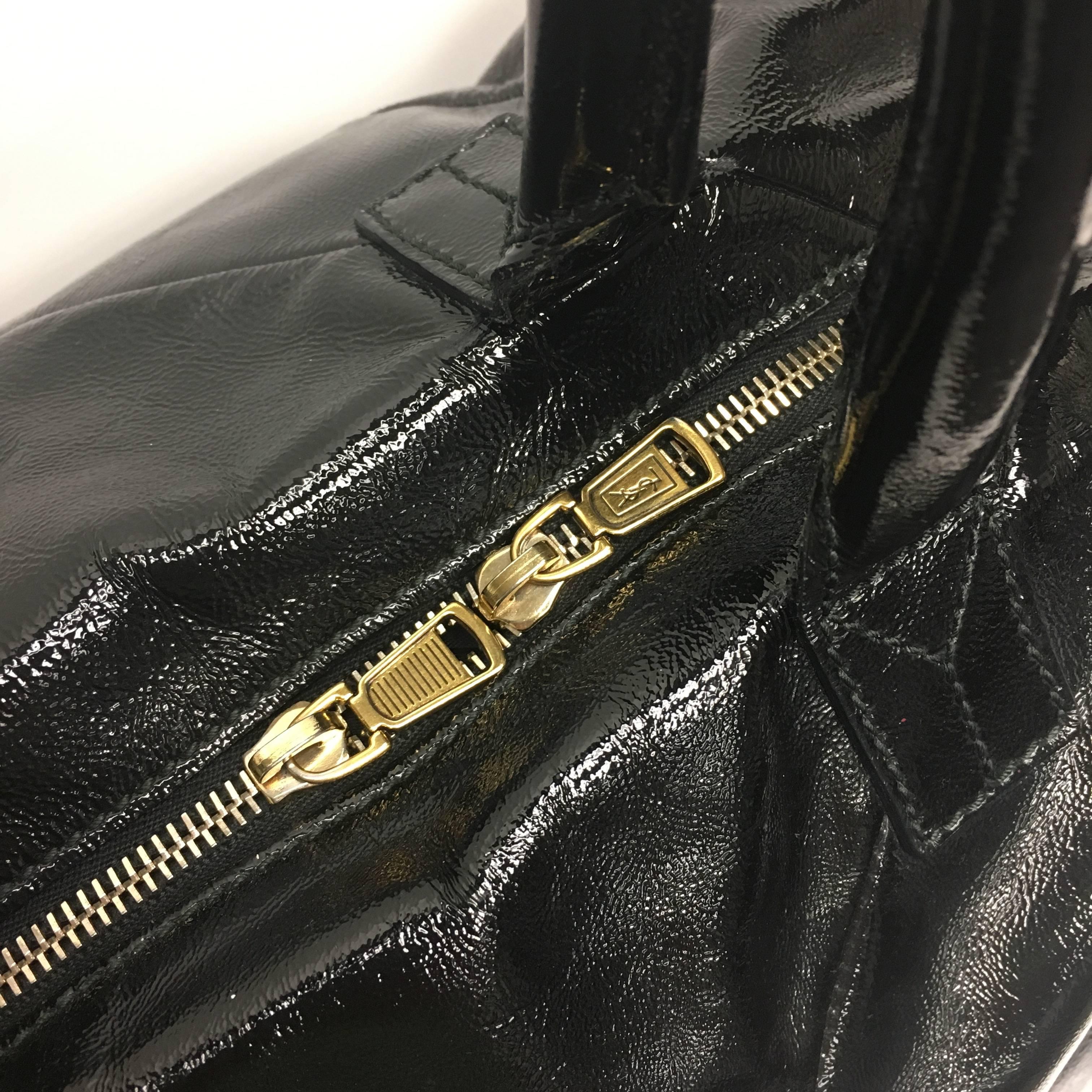 The Easy Y Satchel bag is perfect for your everyday looks. Crafted from black patent leather, this modern, daring bag features leather dual-rolled handles, frontal Y design detail, protective base studs, cinched side button tabs creating a duffle