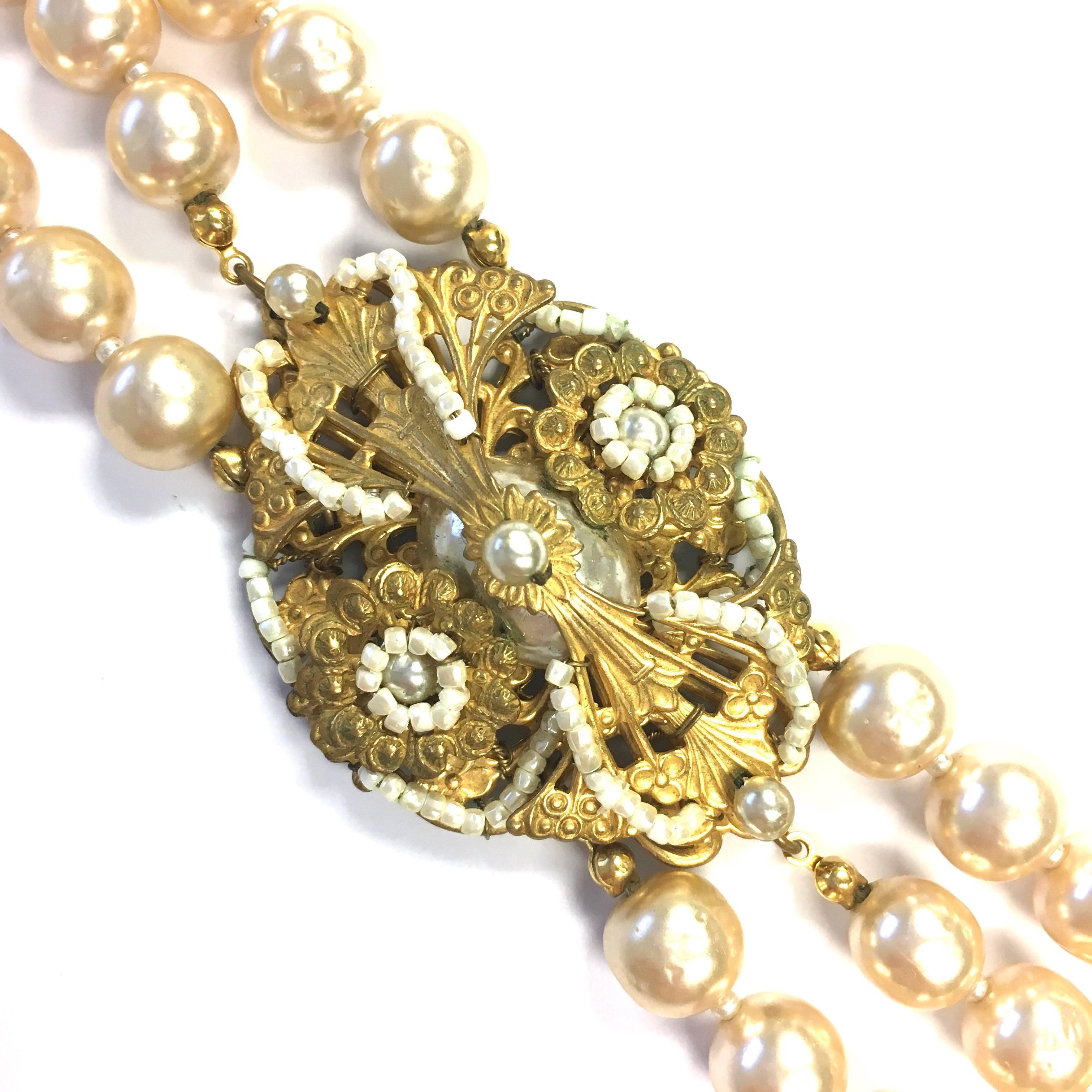 Miriam Haskell faux crinkled cream pearls choker necklace with intricate center piece. Circa 1950's. The pearls measure from 8 mm up to 10.5 mm in diameter. The necklace measures 14 inches in length. 