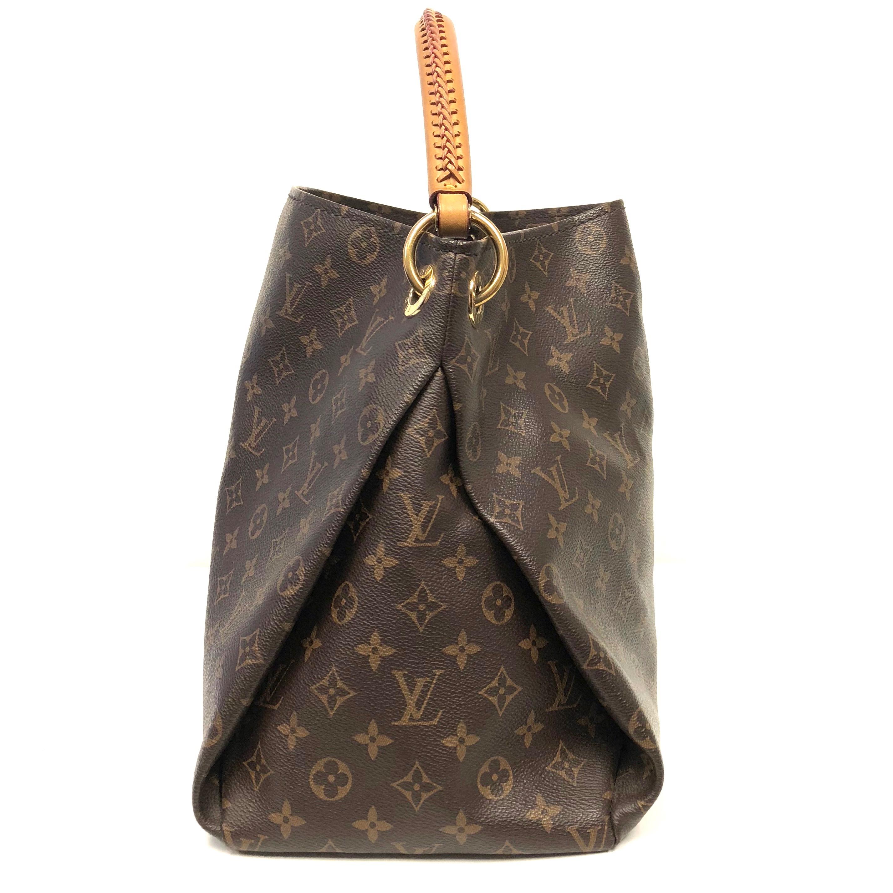 Crafted from Louis Vuitton's iconic brown monogram coated canvas, the bag features a rolled leather handle with braided detailing, protective base studs and gold-tone hardware accents. The bag opens to a beige microfiber interior with a long zipped