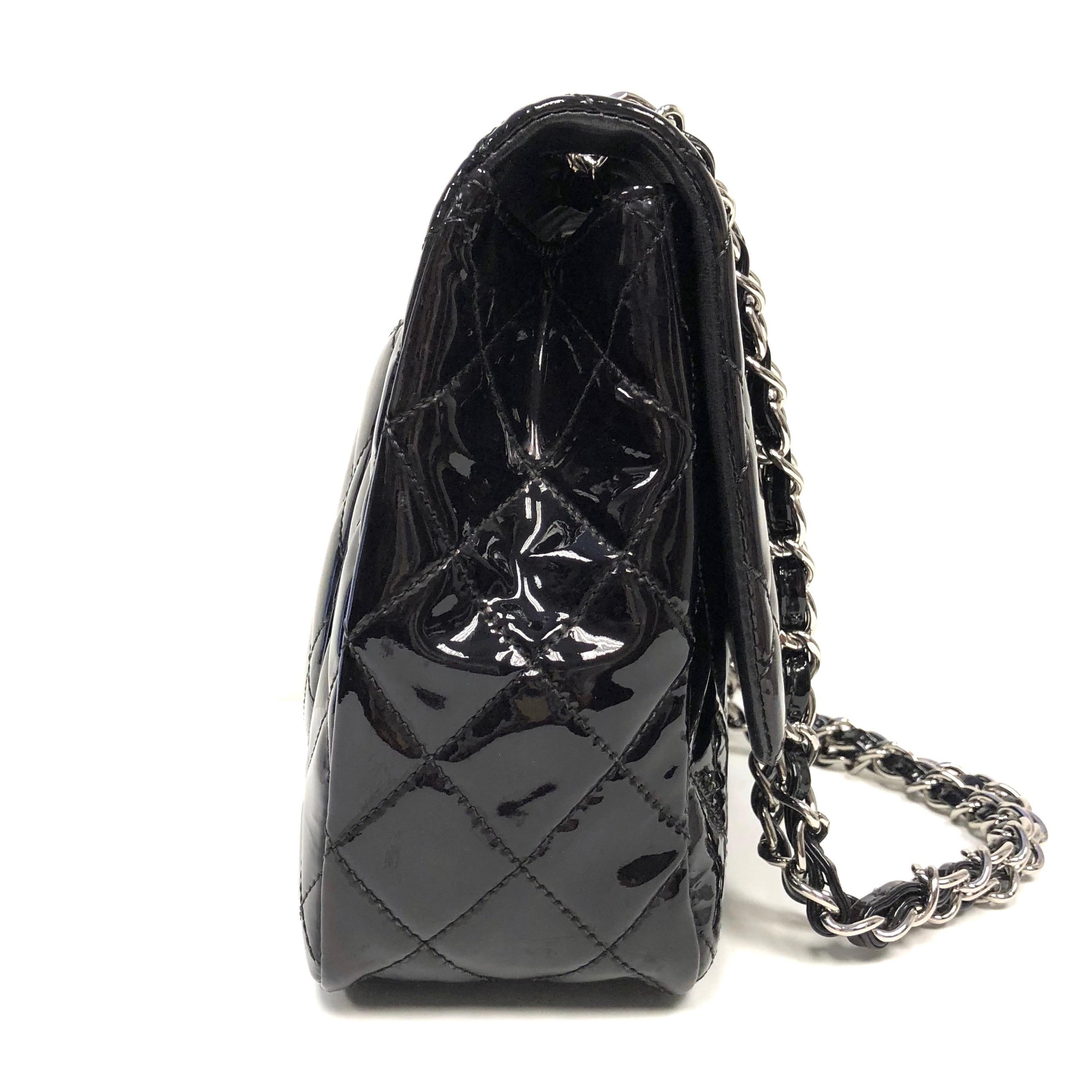 Chanel Classic single flap bag, crafted of fine diamond quilted glossy patent leather in black. The bag features patent leather threaded silver chain shoulder straps and a facing half flap with a silver Chanel CC turn lock. The interior features