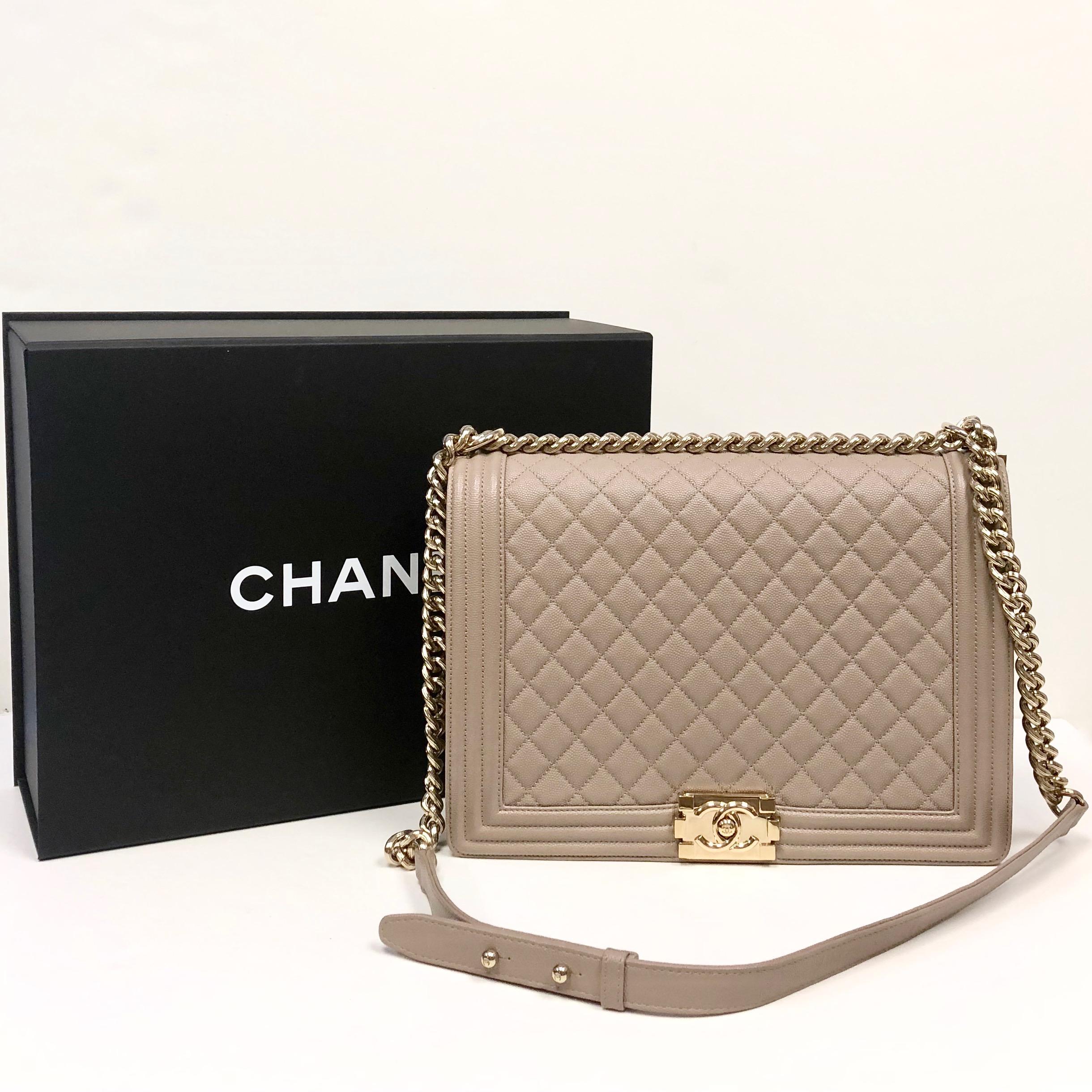 

Chanel large Boy bag of dark beige quilted grained calfskin leather with gold tone hardware. The bag features a full front flap with the Le Boy CC push lock closure and a gold tone chain link and dark beige leather padded shoulder/crossbody strap.