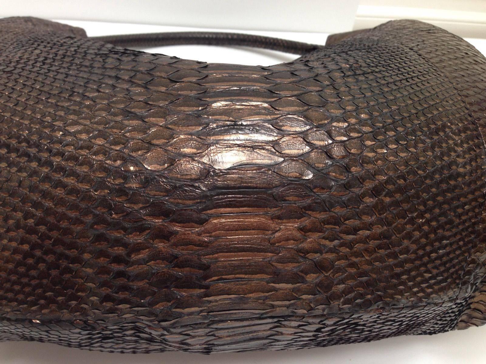  Simple hobo silhouette is elevated to new heights with the finest python skin in a soft black bronze. This is truly an XL bag. The single strap is comfortably worn on the shoulder for toting all the necessary carry-on items. Magnetic closure