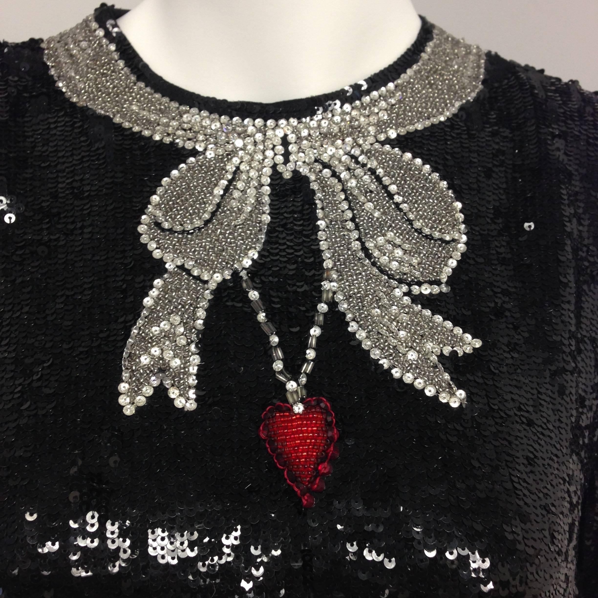 Elegant black sequined cocktail blouse featuring silver ribbons a red heart necklace on chain design. Just gorgeous. It is lined with black silk chiffon. The back fully opens and it has two hook and eye closures on the top and five snap closures on