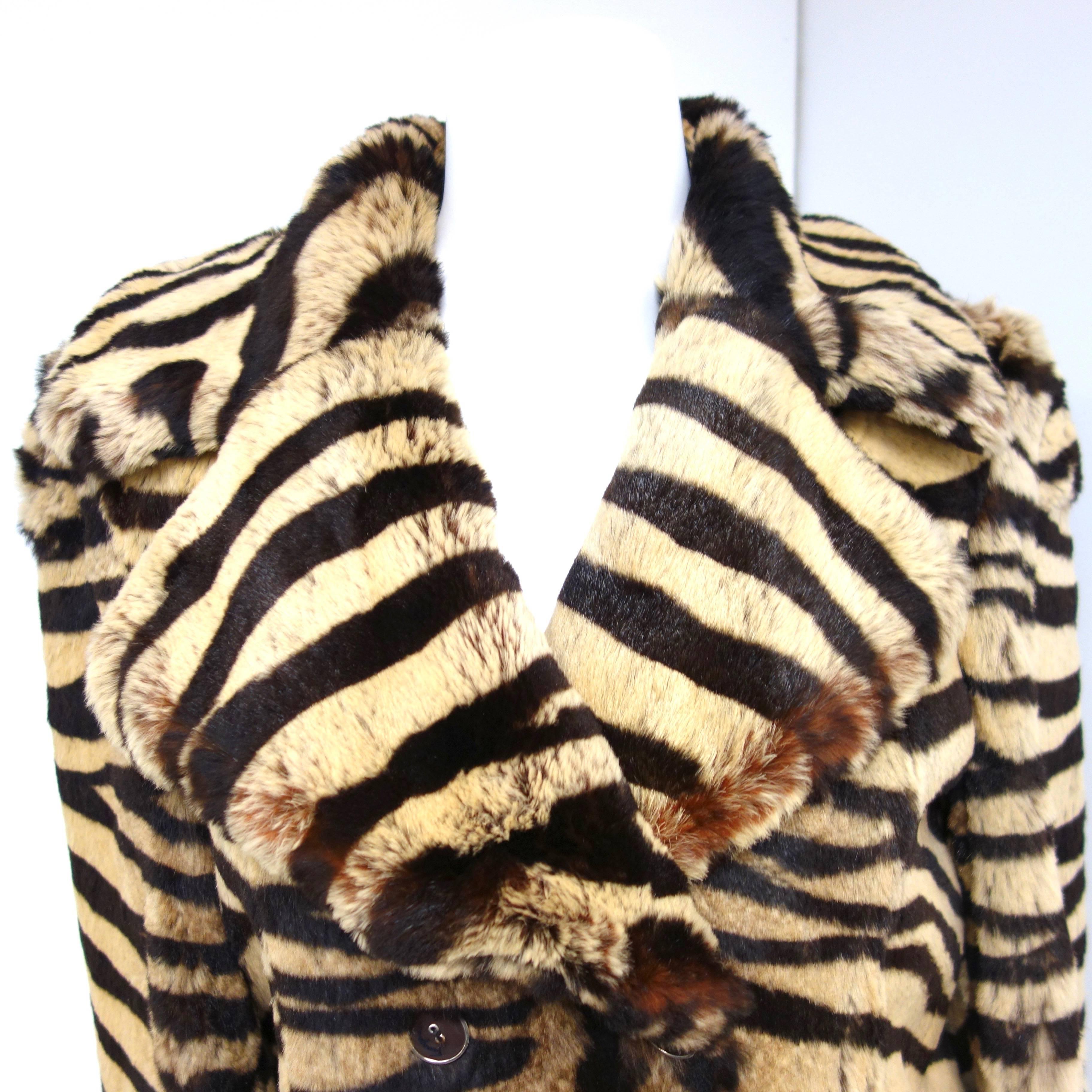 Gorgous tiger print lapin fur 3/4 length, double breasted coat from Salvatore Ferragamo. Large notched collars, leather trimming around the two side pockets, leather and silk lining and signed buttons enhance the beauty of this coat. 
Size stated