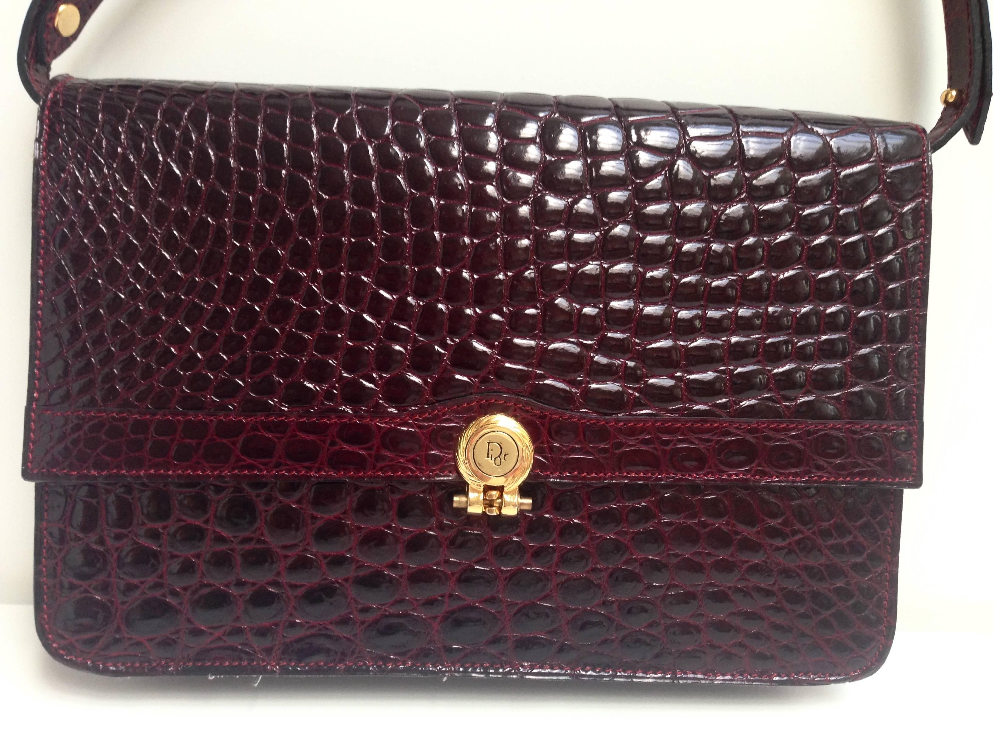 Gorgeous burgundy crocodile purse from Christian Dior from the 1980s.
Single flap opening. Fully lined lether interior, one inside pocket with zipper. Gold hardware. Adjustable strap from 7