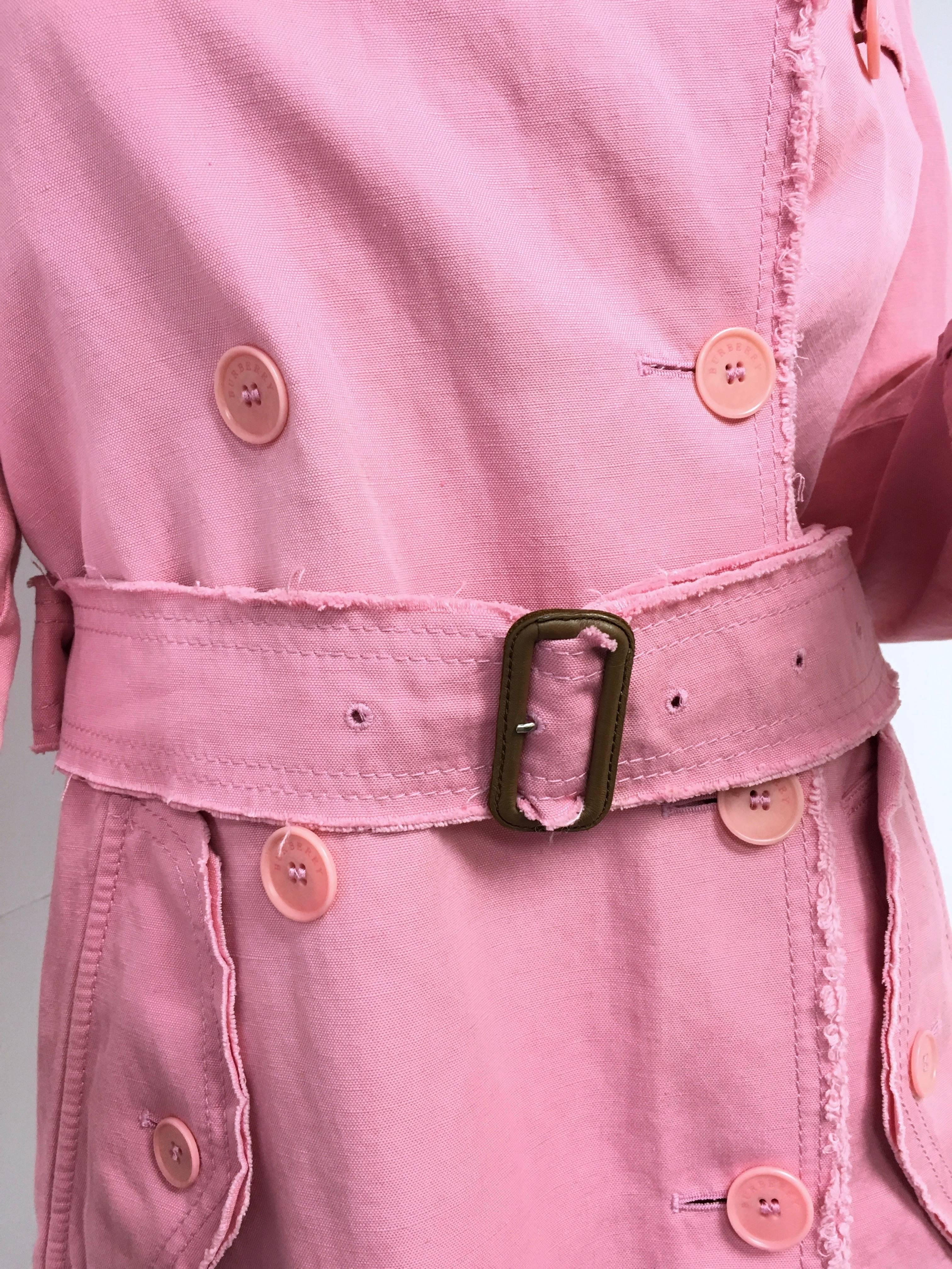 Burberry London pink double breasted trench coat. 
Size Small (4) 
Nova check lining, notched collar, apalettes, dual flap pockets at hip, 
long sleeves with belted cuffs, removable belt at waist.
Closure/Opening: Double breasted button front