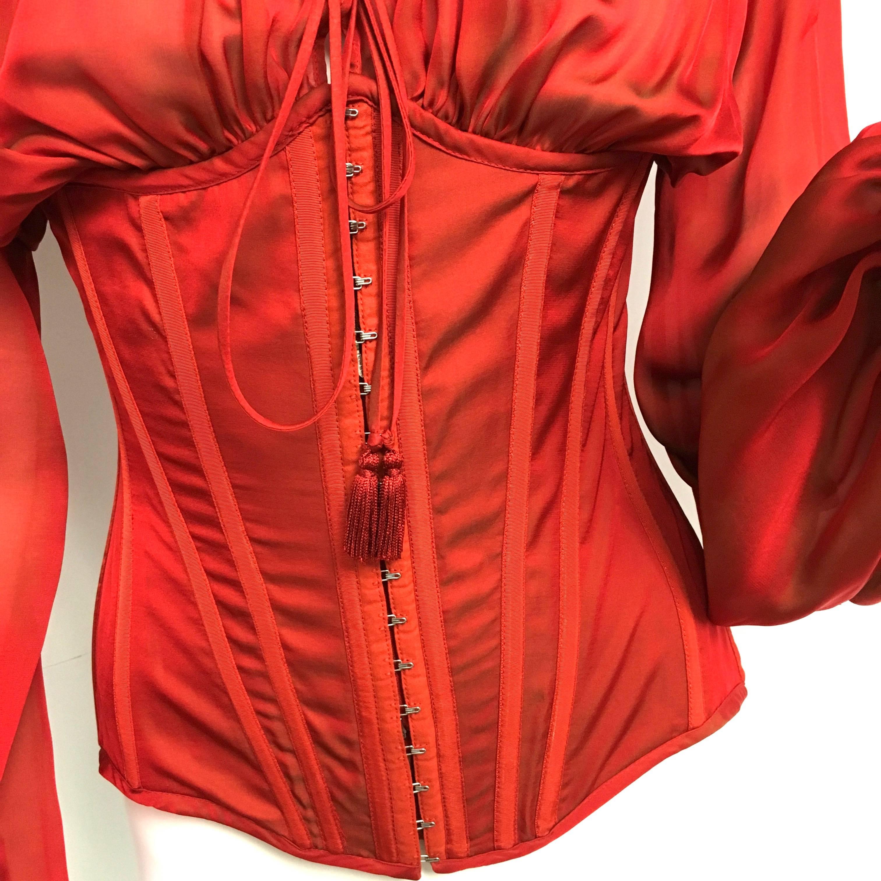 Rare Jean Paul Gaultier Lace Up Corset Irridescent Red Silk Blouse. 
New with Tag.
Size: 38 ITA / 2 US

STYLE: Corset Blouse
CLOSURE: Front Zipper Metal Hooks / Lace up in back
MATERIAL:  100% Silk

Approximate measurements:
Chest -