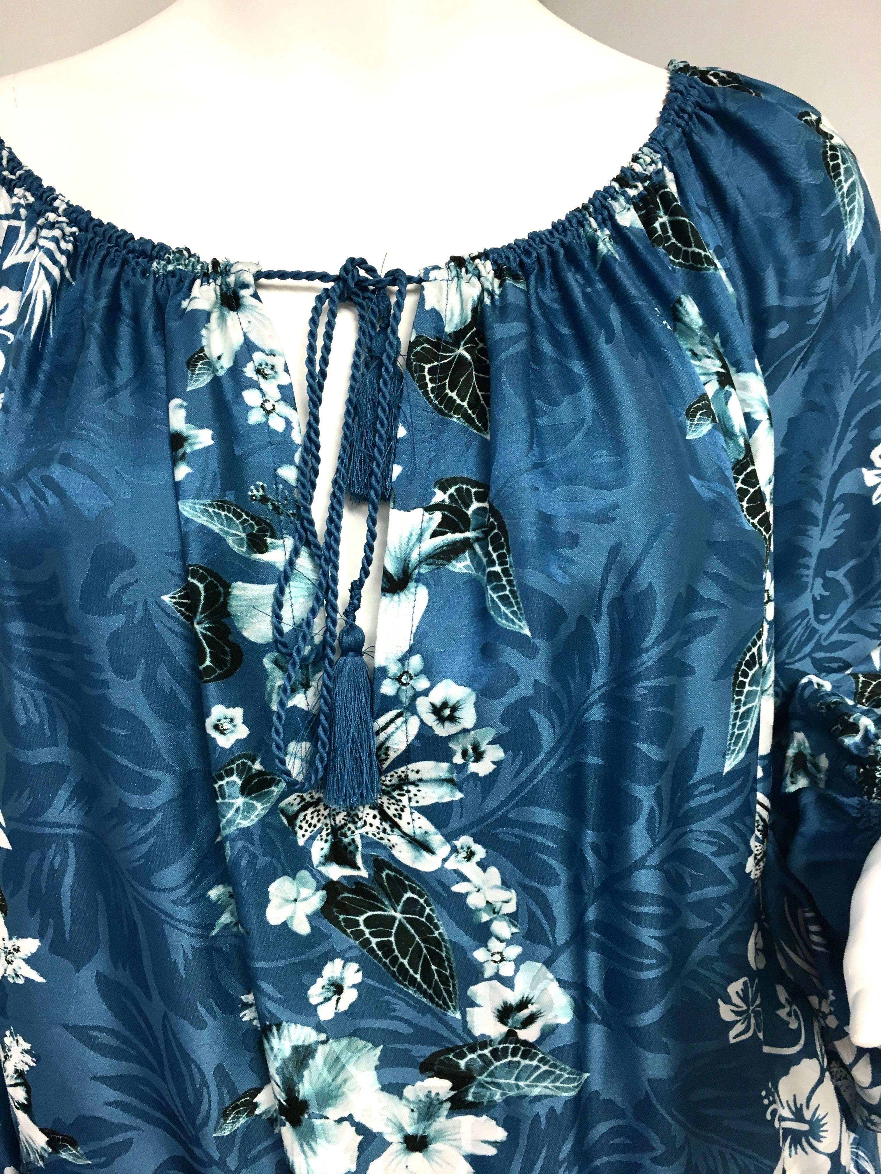 A traditional, tropical Hawaiian print decorates this blouson dress. Long sleeves. Halter neckline with tie closure.  Blouson top. Pullover style. Knee length or a bit above depending upon how much blouson you want. Size 42 ITA / 8 US. Approximate