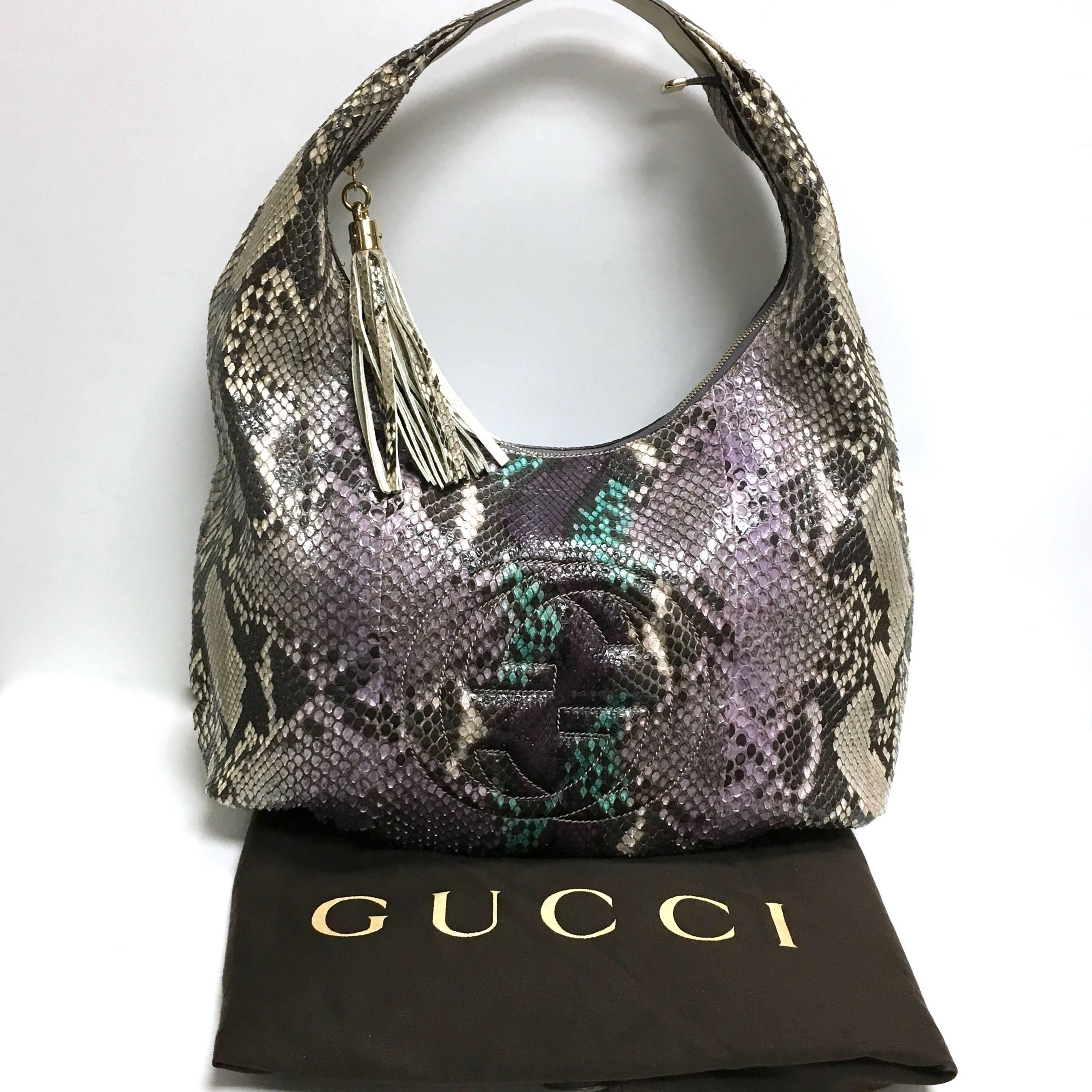 This statement hobo is crafted of exquisite python with purple, turquoise, and mauve accents. The bag features a looping shoulder strap, a frontal stitched interlocking GG logo and a brass knobbed python tassel zipper pull. The top unzips to a