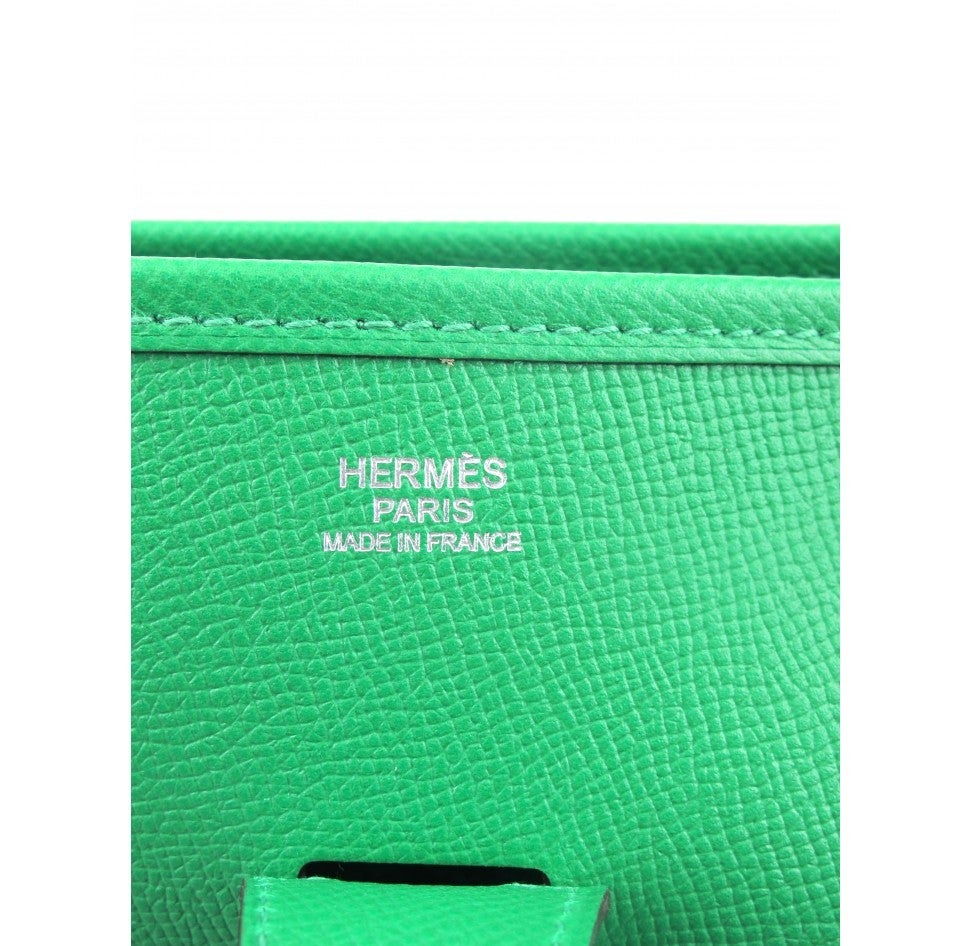 Brand new HERMES Evelyne purse in Bambou Green. GM sizing. 

The bag is constructed with gorgeous Clemence leather and palladium hardware. The bag is the 2014 styling with a large pocket on the back of the shoulder bag. The bag has a button snap