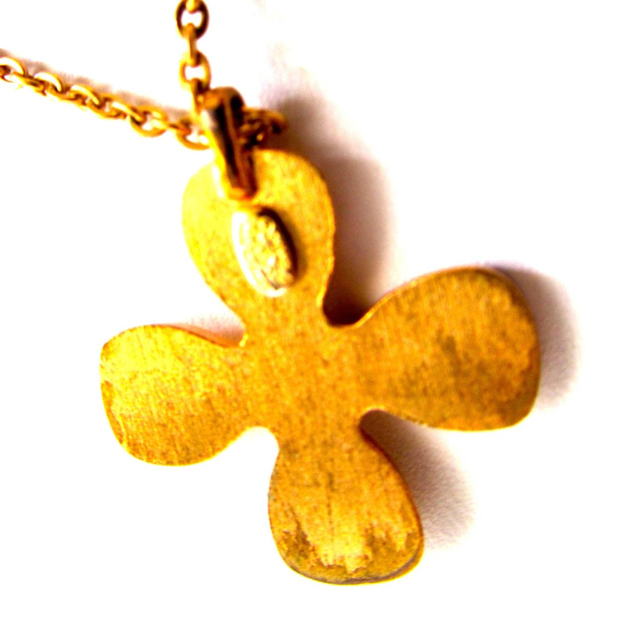 Chanel Necklace from the late 1990's. Gold toned chain with charm. Crystals are inlaid into charm to form a cross shape inscribed on the interior of the clover shape. Chanel CC logo is on the center of the charm. Chain is 15 inches long. 0.9 inches