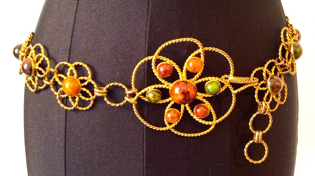Extremely rare and iconic piece. Intricate gold tone chain belt with flower design and Cabachon stones. Surrounded by swirled gold toned chain. Hidden clasp behind large center flower. Massive center flower is 3.75 inches  wide and 4 inches high.