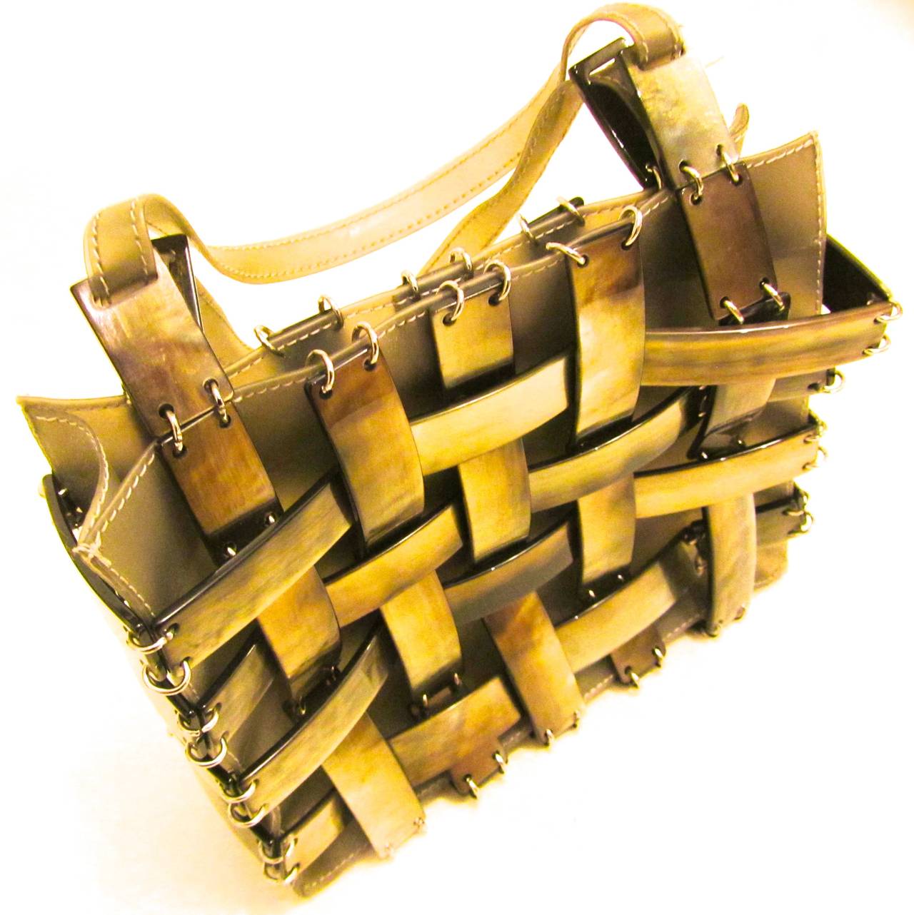 This beautiful Bottega Veneta handbag has never been used. It is from the 1980's. It is woven mother of pearl over a clear plastic lining attached by grommets. It is extremely rare and perfect for any occasion. 

5 inche strap drop.