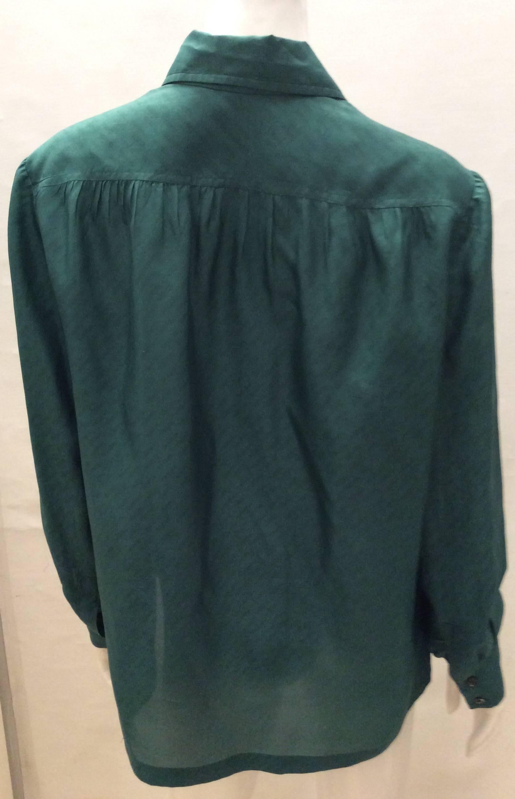 This Hermes teal blouse is a magnificent silk blouse in size 48. It can fit a variety of sizings depending upon the desired fitting. It can fit smaller if the desired fitting is a looser more flowing fitting or a larger sizing if a more form fitting
