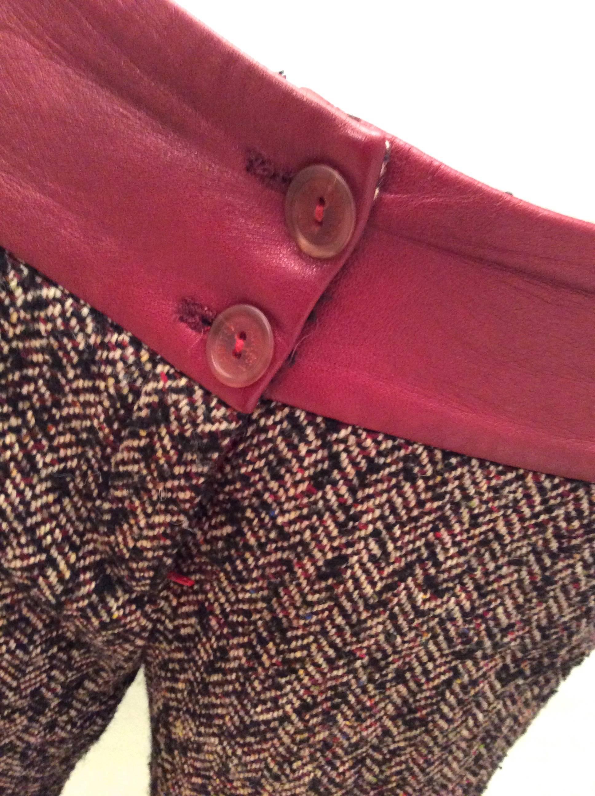 This pair of gaucho pants from the 1970's is a beautiful combination of an acrylic wood blend with red leather trim at the waist of the jacket. The wool acrylic blend is a threaded pattern of red, black, and white woven into a diagonal pattern. The