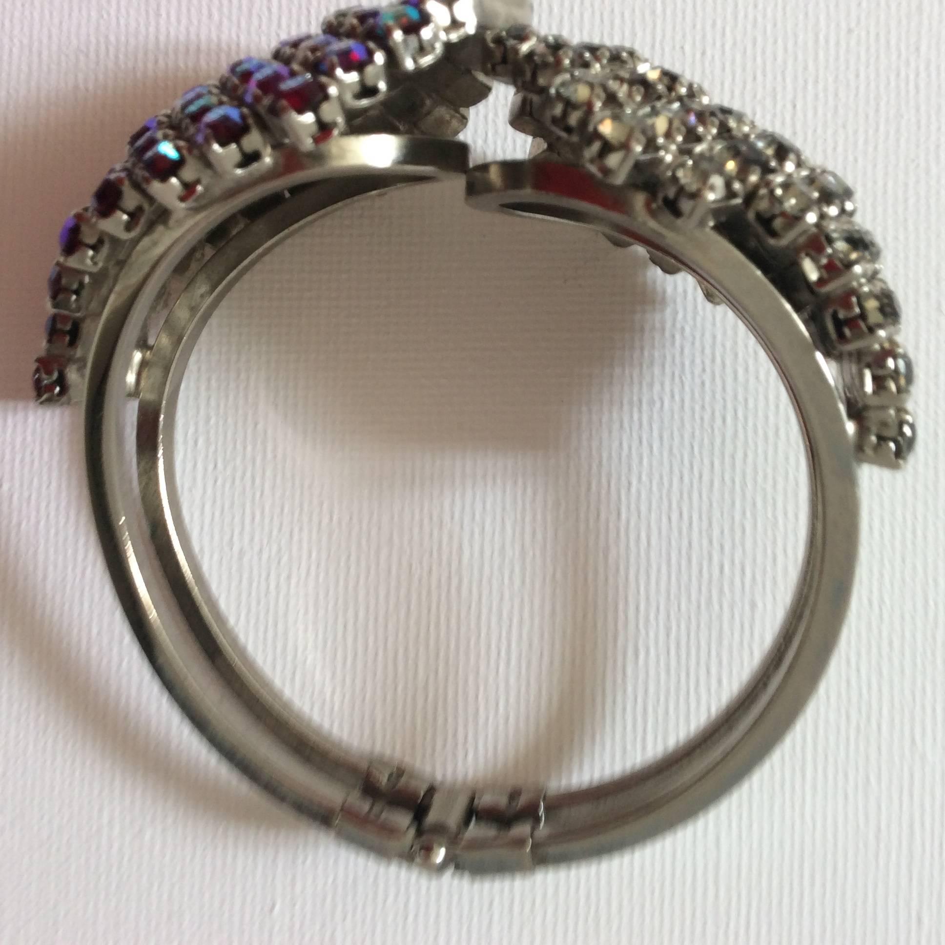 Presented here is a gorgeous Juliana clamper bracelet from the 1960's. The bracelet has aurora borealis and clear rhinestones on the bracelet. The bracelet's 'clamper' closure is retractable. The bracelet opens at center of the top face of the