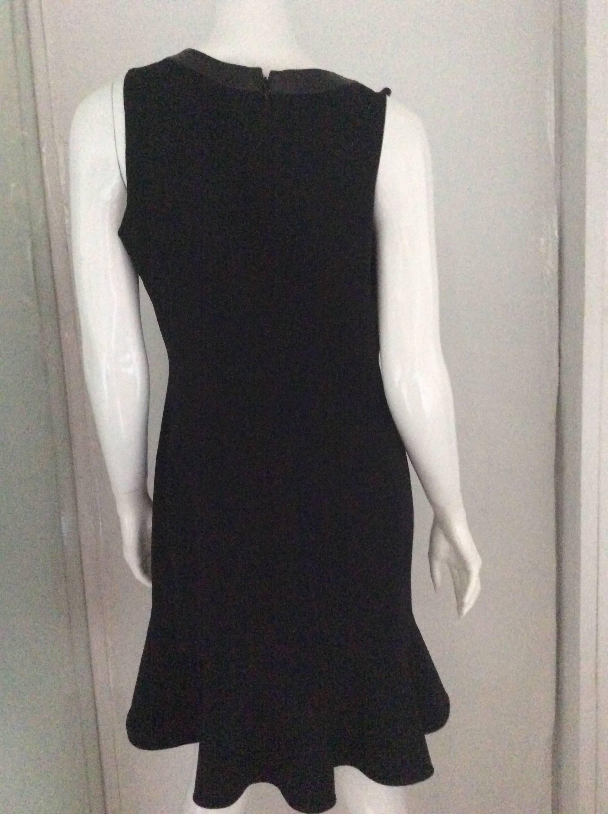 This dress just might be your perfect little black dress for all occasions. The sleeveless dress has a 1 inch leather trim around the neck and a 6.5 inch flounce at the bottom of the dress. It is a US size 10 (please pay close attention to the