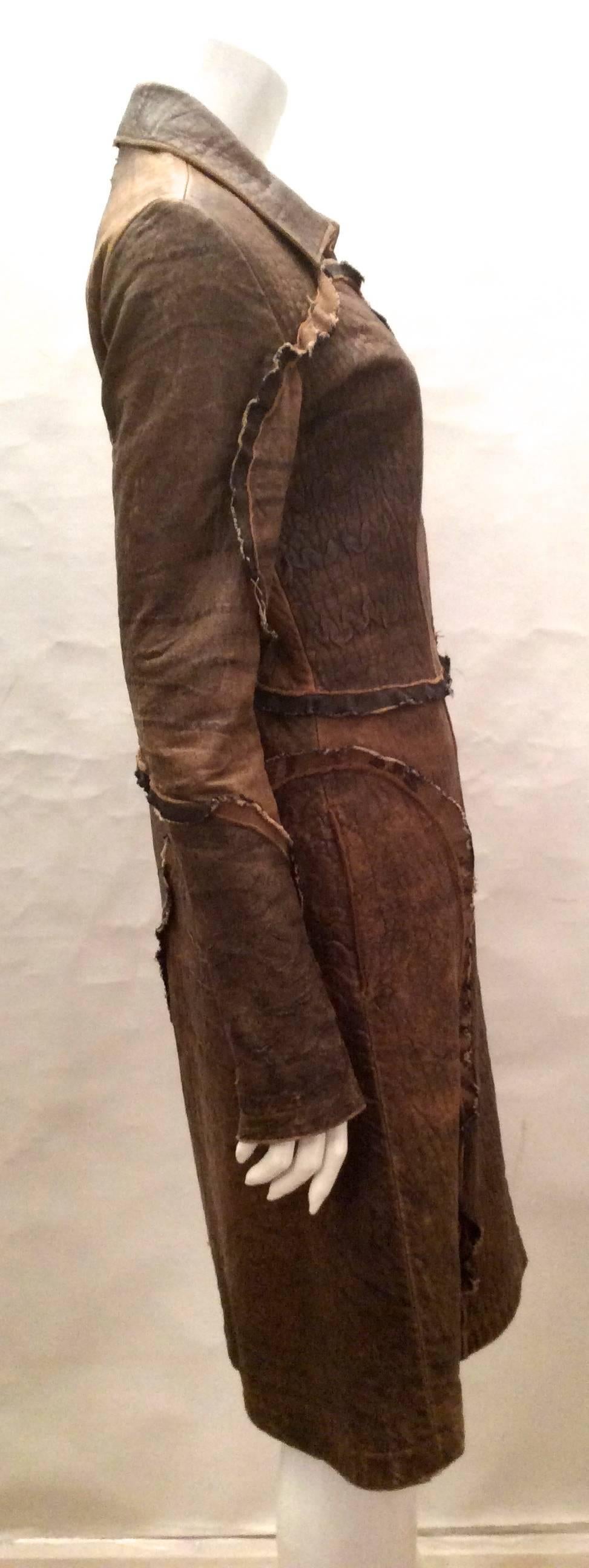 This distressed brown leather jacket from the designers at Roberto Cavalli is a gorgeous array of various tons of brown leather. The overall tone of the browns generates a tobacco brown color tone. 

The 1/2 inch black brown trim is striated with