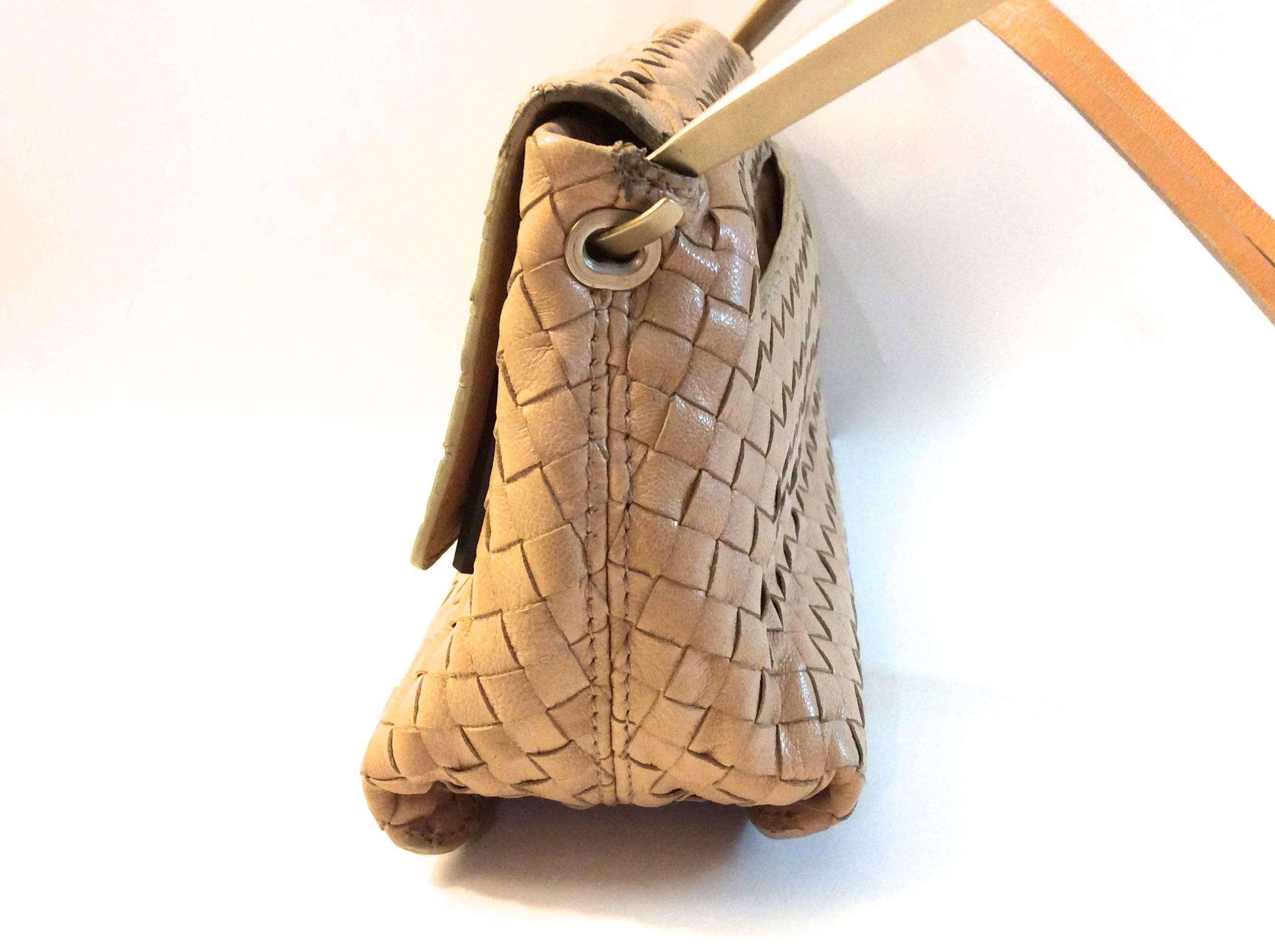 This beautiful Bottega Veneta handbag is beige. It is a small handle bag with one exterior non-zip pocket, and one interior zip pocket. The exterior leather of the bag is in excellent condition with little to no signs of wear. The magnet inside of