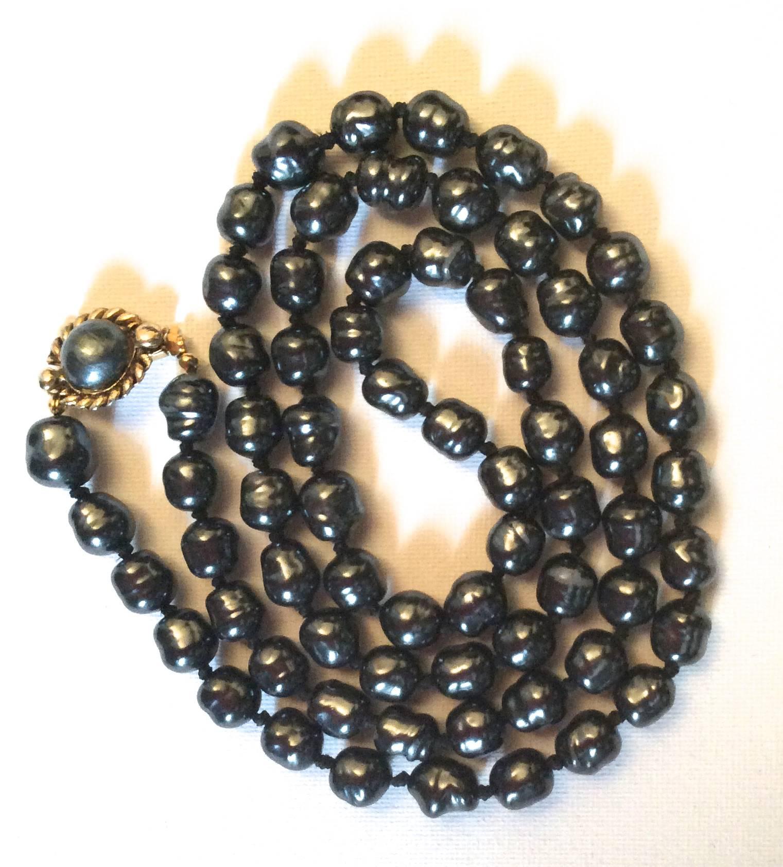 Presented here is a dark gray pearl necklace from Chanel. The necklace is comprised of dark gray pearls irregularly shaped pearls. The shape is more oval-like than a sphere. Please see photography for details of the shape of the pearls. The pearls