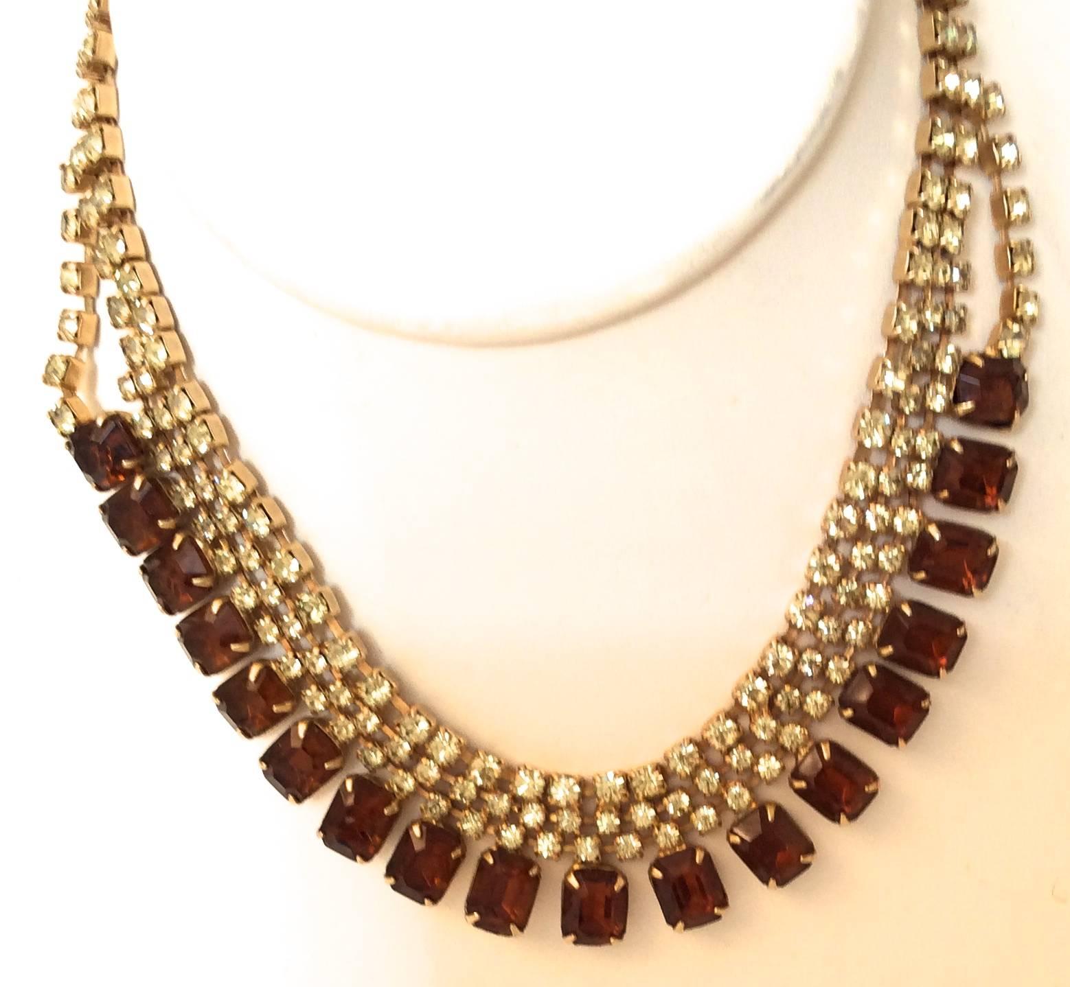 Presented here is a beautiful rhinestone necklace from the 1950's. There is one row of emerald shape amber colored rhinestones on the front of the necklace. There are an additional 3 strands of smaller yellow rhinestones throughout the length of the