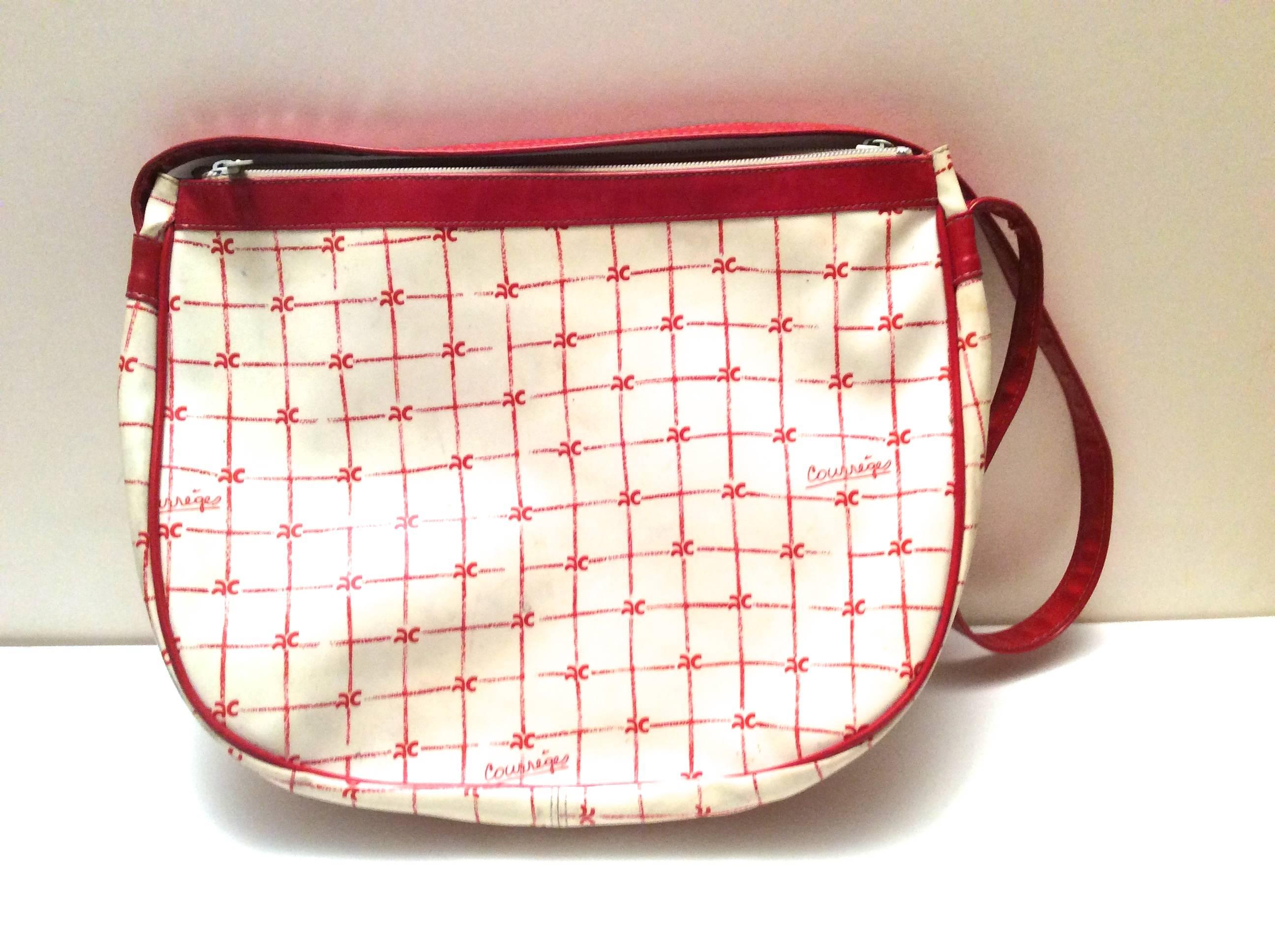 This rare Courreges Purse from the early 1970's is a magnificent example of vintage Courreges. The bag is comprised of two large zippered pockets on either side, with a large main opening in the center of the bag. The bag has a red shoulder strap.