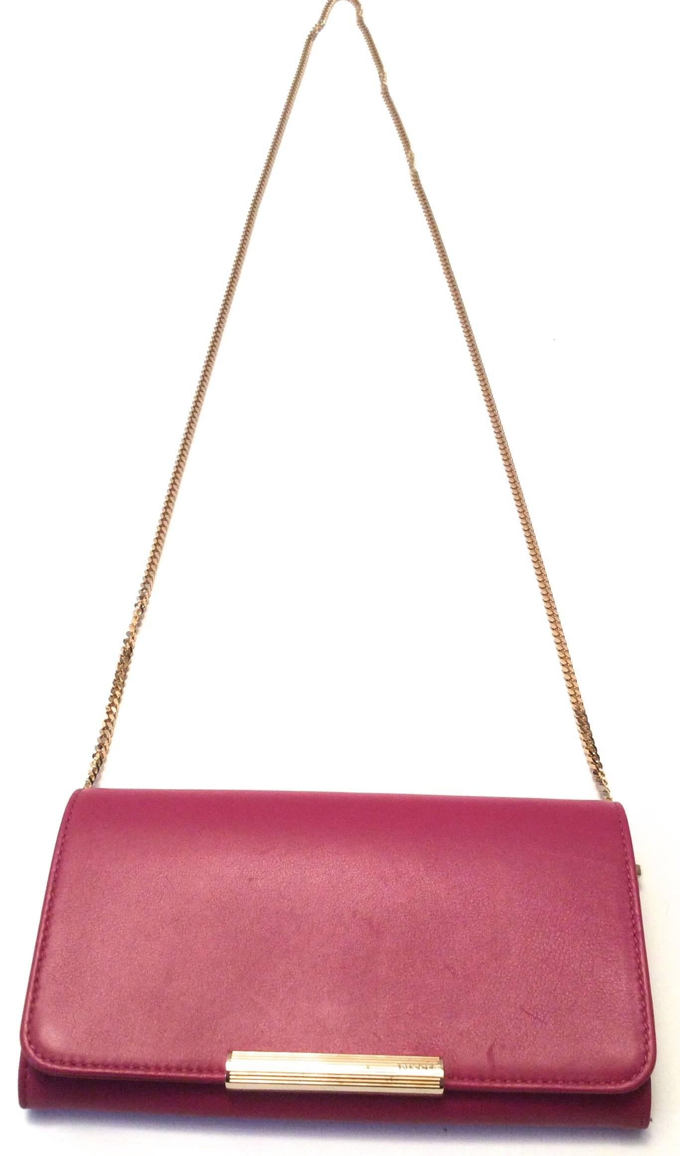 This beautiful Pucci Wallet-on-a-chain is a fabulous fuchsia leather with a beautiful gold tone snap enclosure with Pucci written out on the bottom right. When you open the beautiful bag, the lining is beautiful orange, lavender, and fuchsia