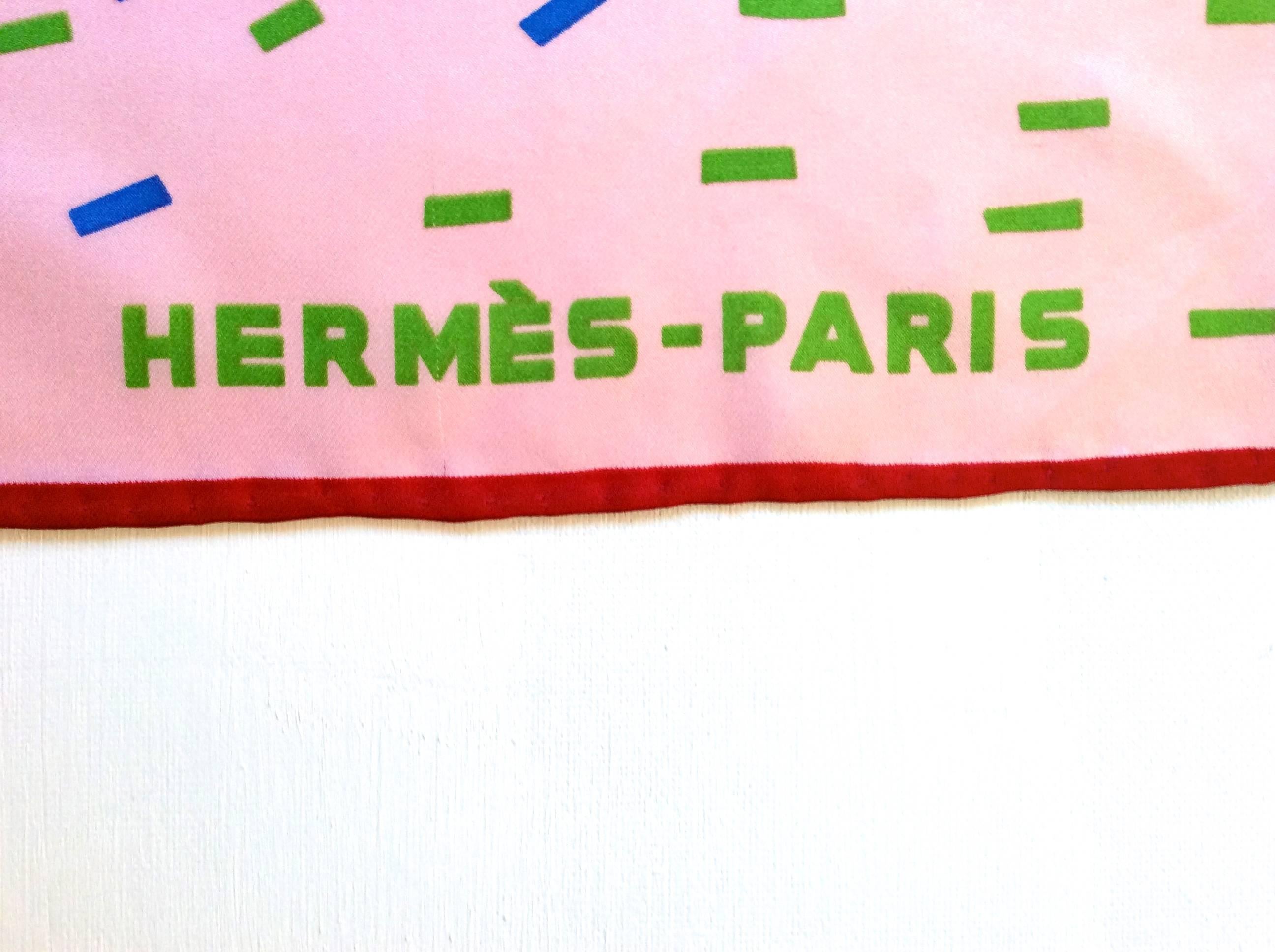 Presented here is a scarf by Hermes Paris. The scarf is 100% silk and is an image of fireworks with a pink backdrop. The scarf is versatile for various outfits and occasions. An excellent example of the design work from the artists at Hermes. The