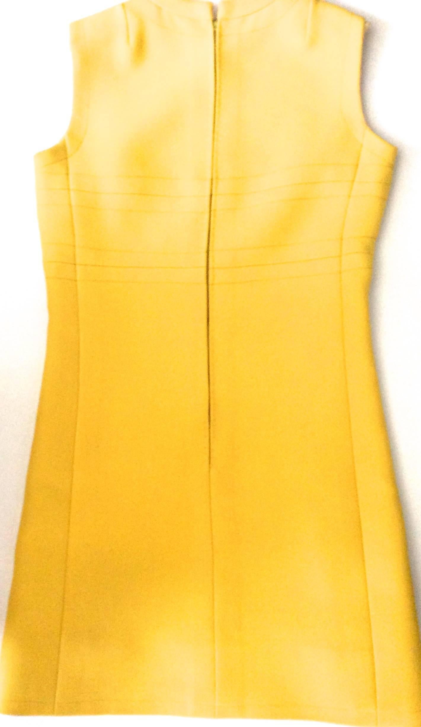 Presented here is a vintage 1960's yellow sleeveless a-line dress. The dress is wool with cream colored silk lining. The dress is carefully stitched throughout the entirety of the dress. The dress has beautifully stitched cross sections sewn in