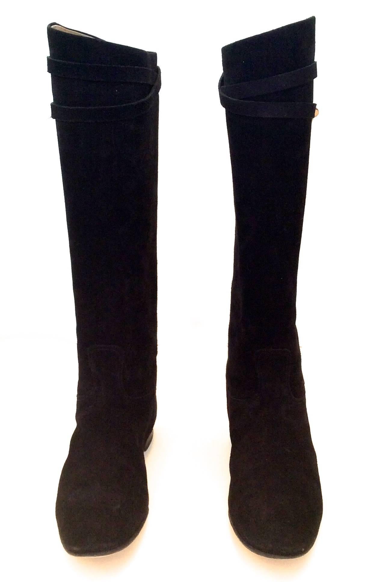 Presented here is a fabulous pair of Hermes black suede riding boots. They are like new and have been worn once. They are size 37.5 / US 7.5. The boot is adorned with a .25 inch suede strap. Silver tone medor style rivale hardware is fastened to the