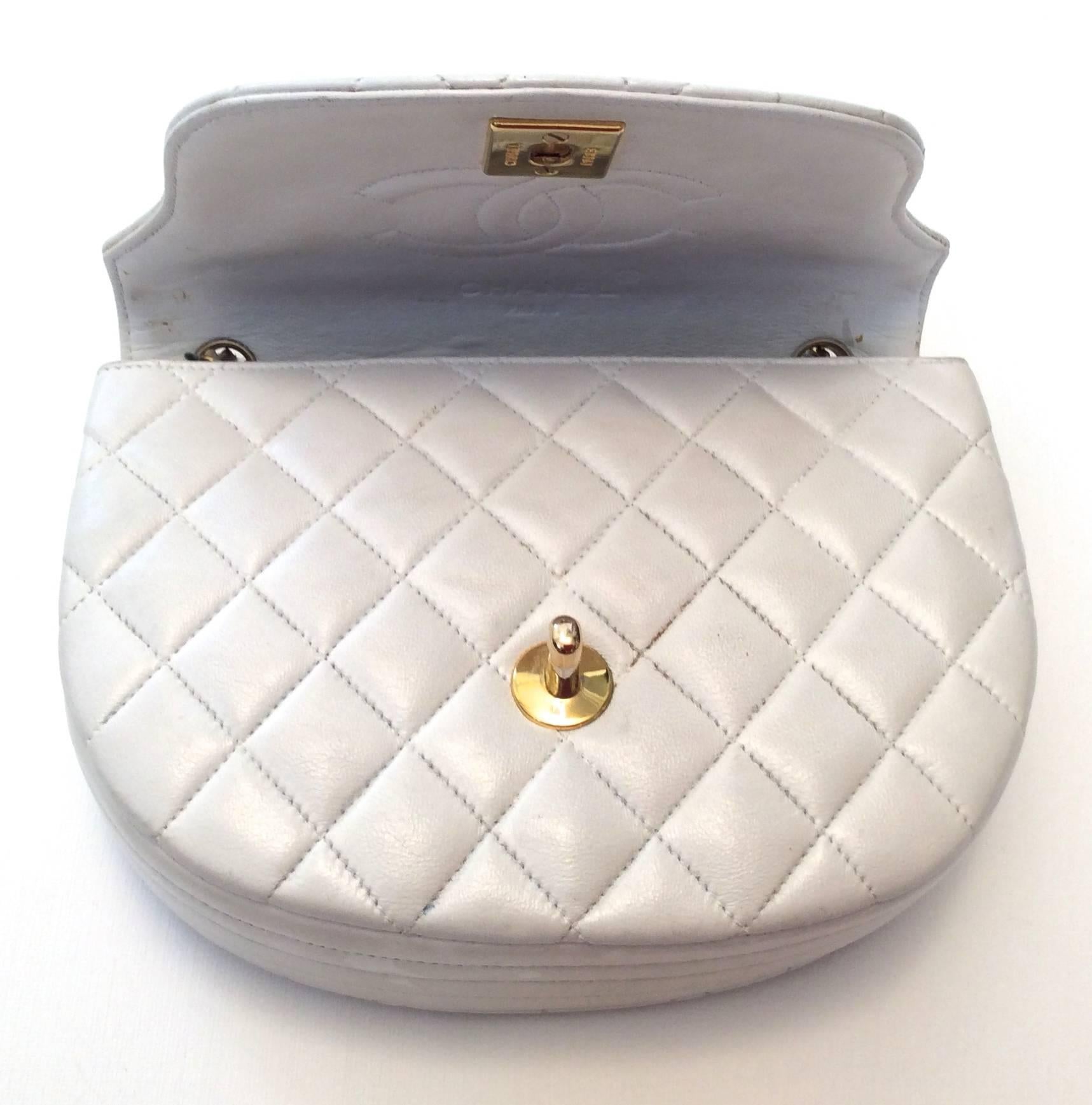 Presented here is a beautiful Chanel mini classic purse. The purse is white leather with gold hardware. The bag has the iconic CC clasp on the front flap to close the bag. On the interior flap of the bag, the bag is signed with a stitched in CC logo