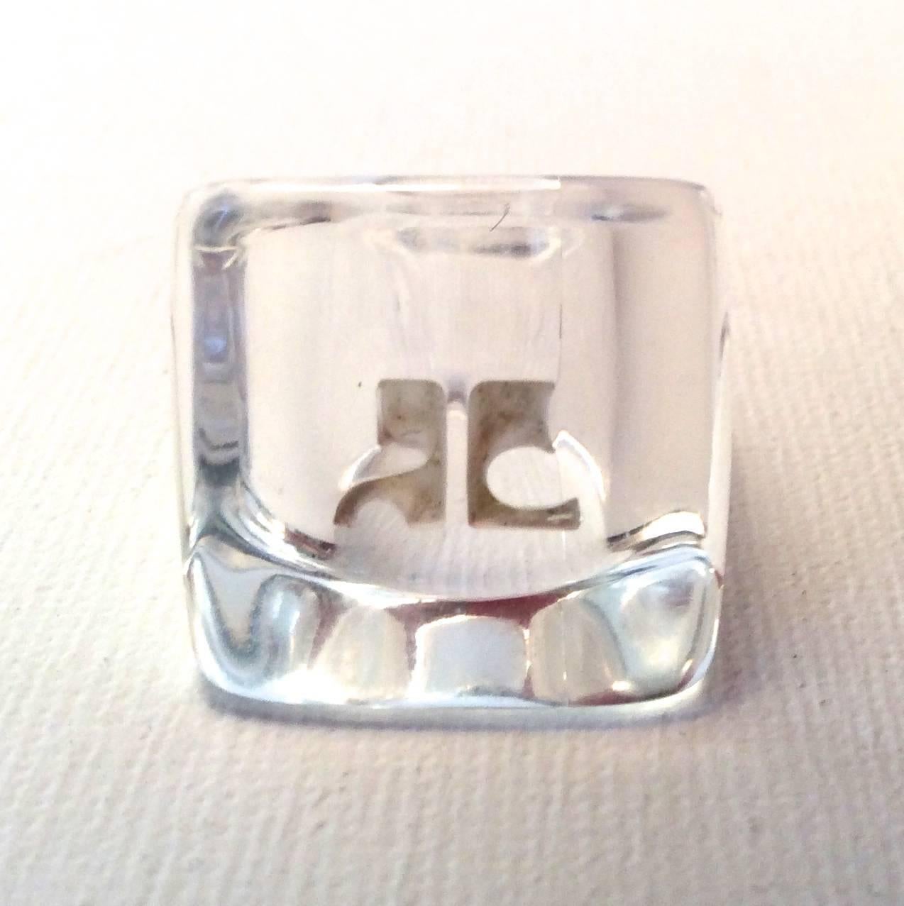 Presented here is fantastic Courreges lucite ring. The ring is lucite and is engraven with the iconic Coureges logo. The ring forms a square shape and is 3/4 of an inch on each side of the ring face. Ring is approximately a size 7 to a 7.5 US. Ring