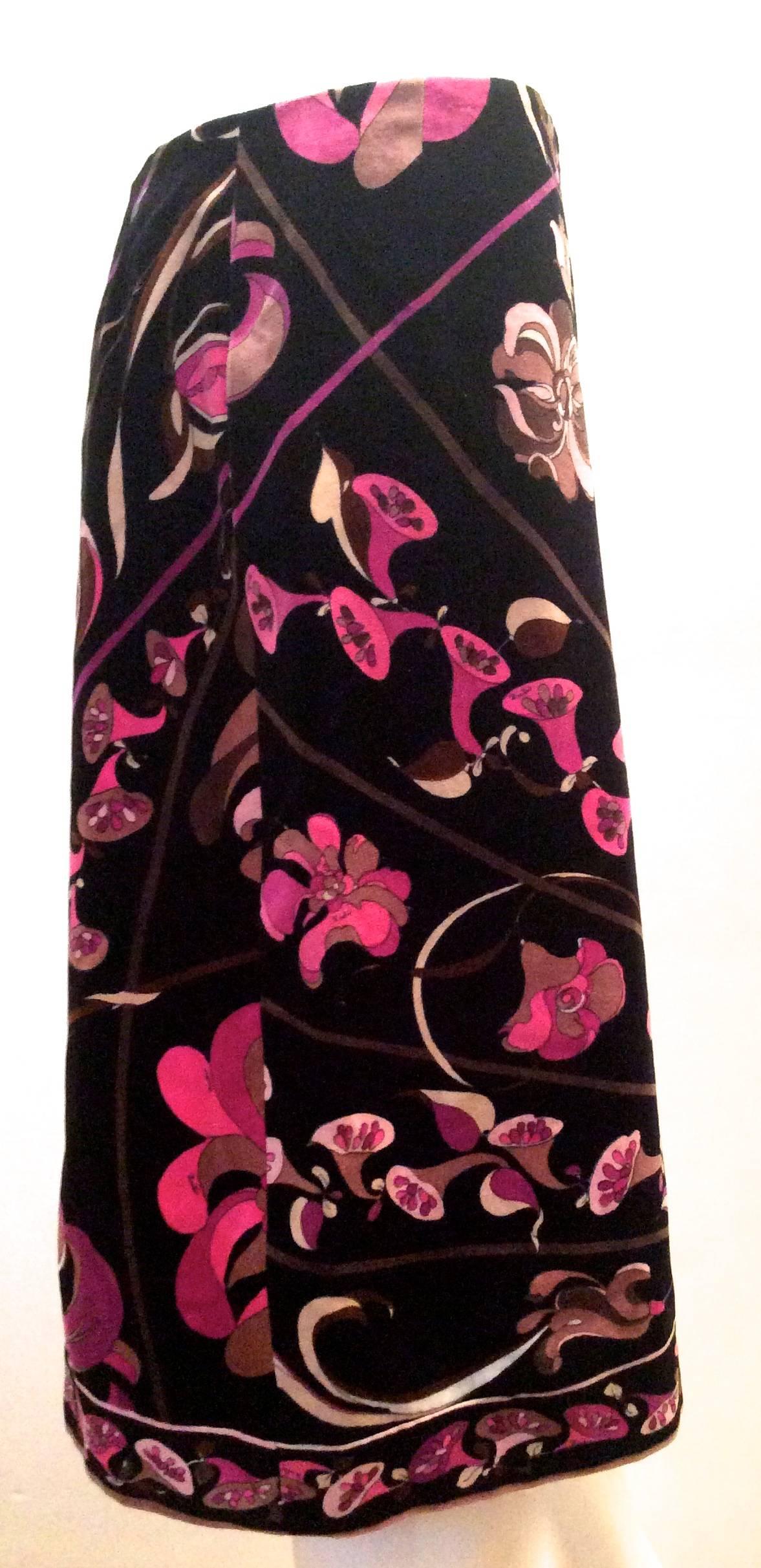 Presented here is a beautiful Emilio Pucci black velvet skirt. It has a vibrant pattern of various shades of pink from fuschia to hot pink to light pink flowers with trim and floral highlights in various shades of dark brown, beige and taupe. There