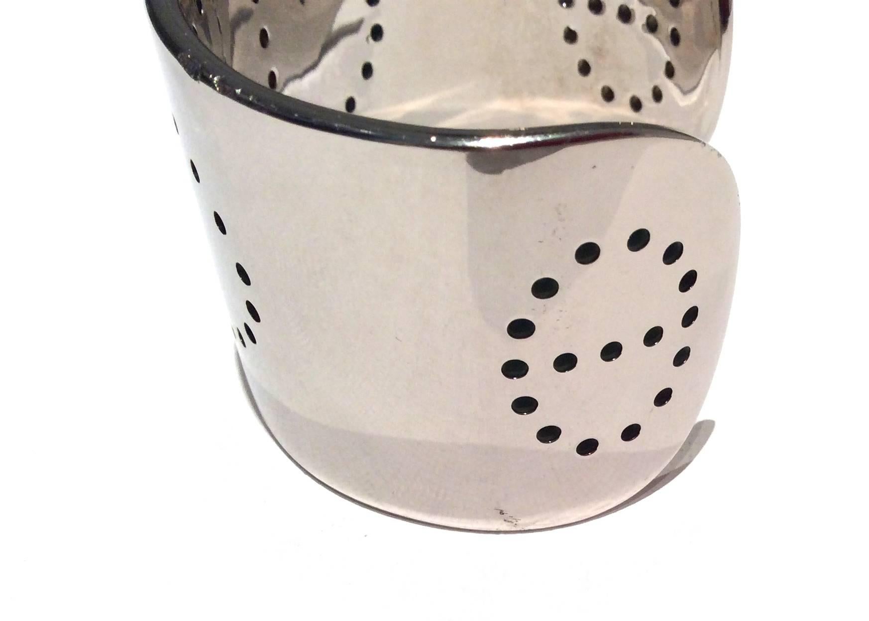 Presented here is an Hermes Eclipse cuff bracelet. The bracelet is solid sterling silver throughout. The bracelet has the classic perforated 'H' on the center of the cuff. There are two perforated circles on either end of the cuff as well. The total