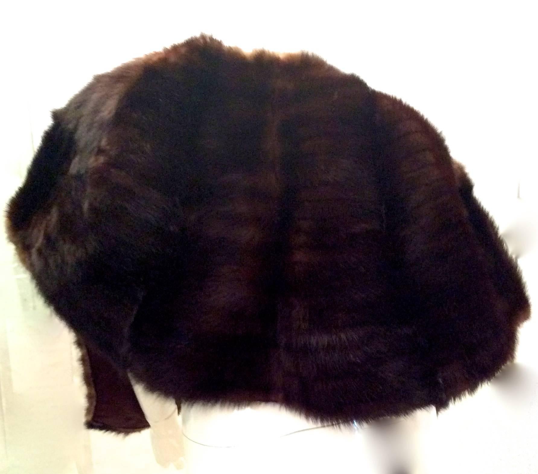 Presented here is a beautiful dark brown mink shawl in excellent condition. It wraps around the shoulders and has two front invisible pockets which makes it perfect for that chilly night or that black tie event. The measurement from the back of the