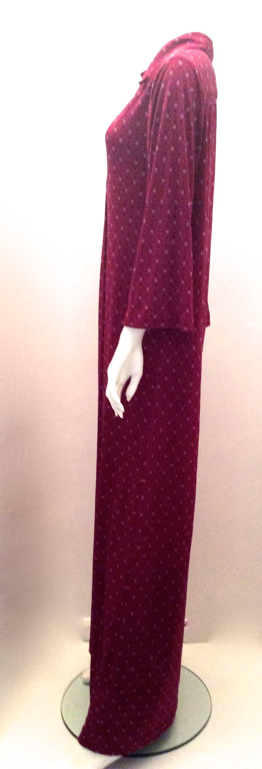 Presented here is a gorgeous vintage Christian Dior Maxi Day Dress. The dress is from the Miss Dior line. The dress is from the 1970's. The dress has a maroon background with red 'CD' logos and small flower like shapes that are pink. The dress is a