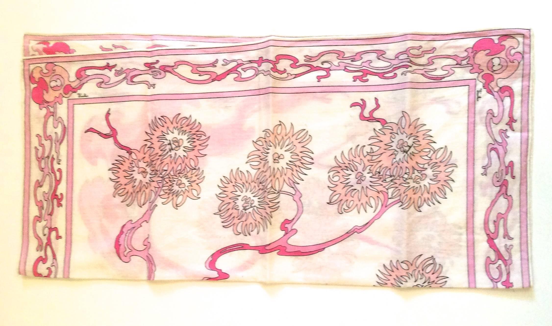 Presented here is a beautiful vintage 1960's scarf from the Emilio Pucci fashion house. The scarf is a white scarf with varying shades of pink in a floral print. Pucci has long been a label associated with its unique and mystifying design prints and