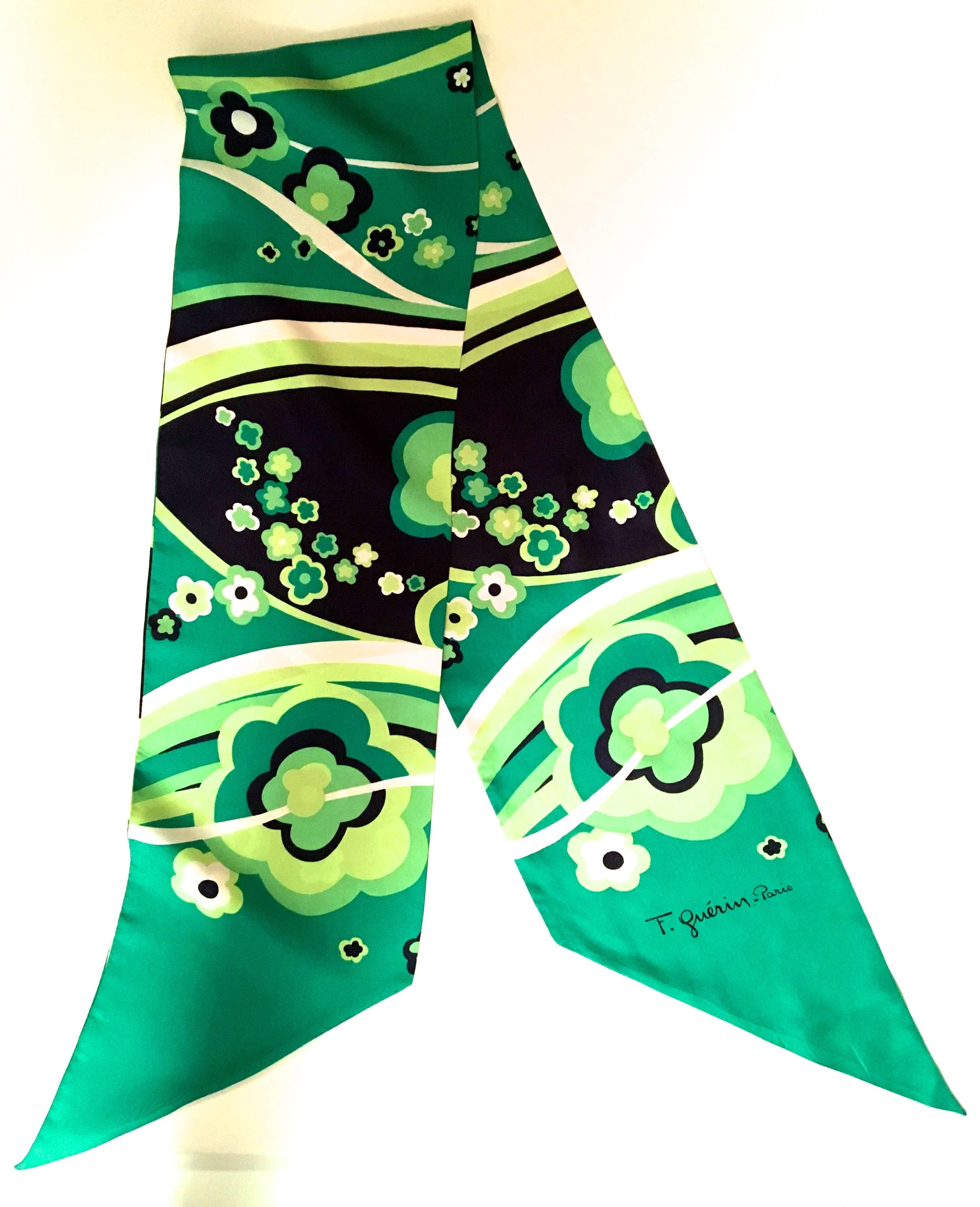 Presented here is a lovely vintage scarf from F. Guerin Paris from the 1970's. The scarf is comprised of varying shades of green, dark blue, and white. The scarf is a geometric floral print typical of the era. The total length of the scarf is 55